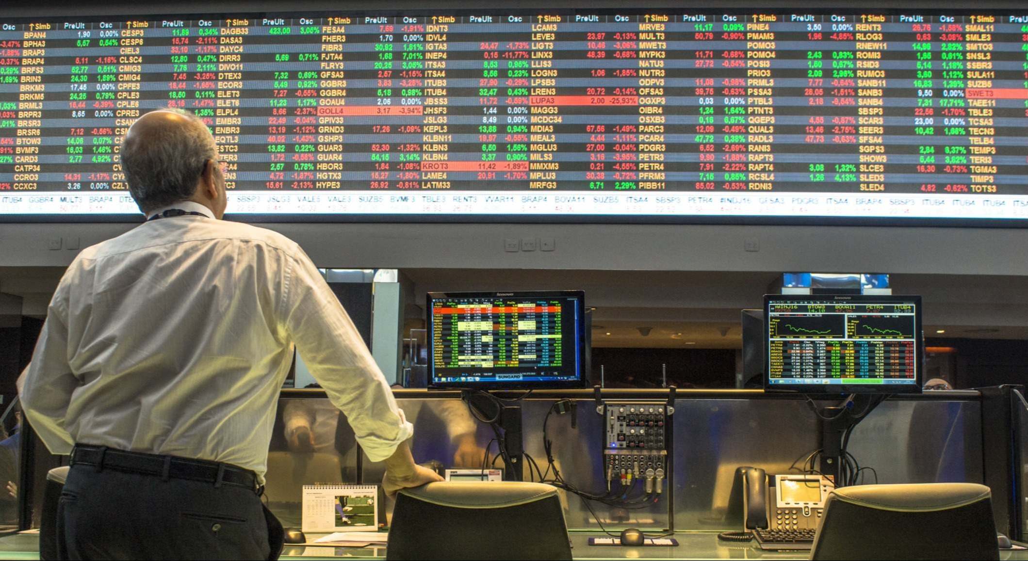 Un broker mirando los paneles de la bolsa