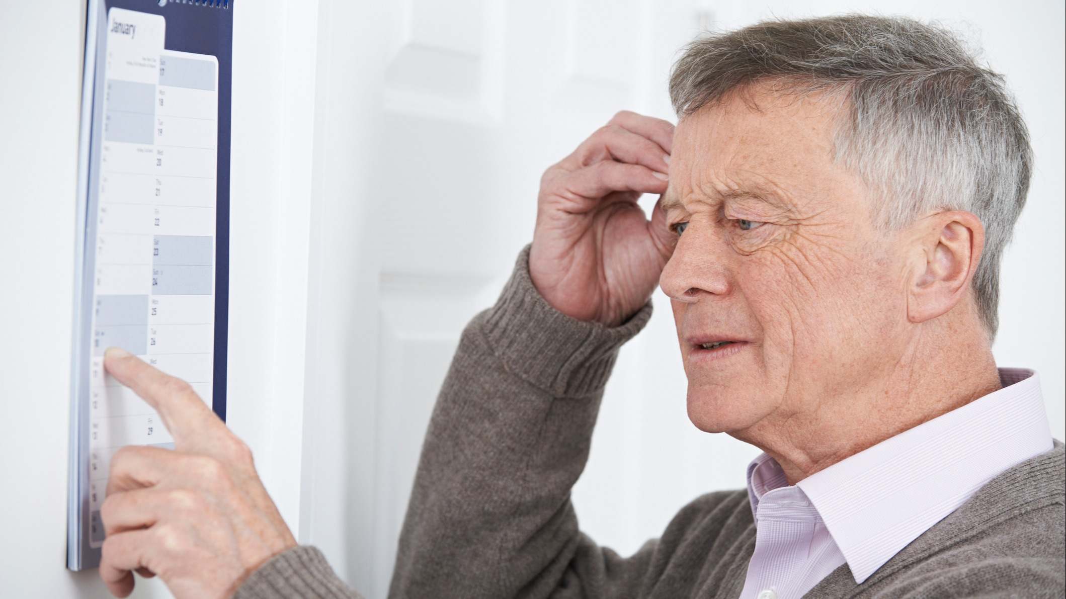 Un hombre observando un calendario de pared