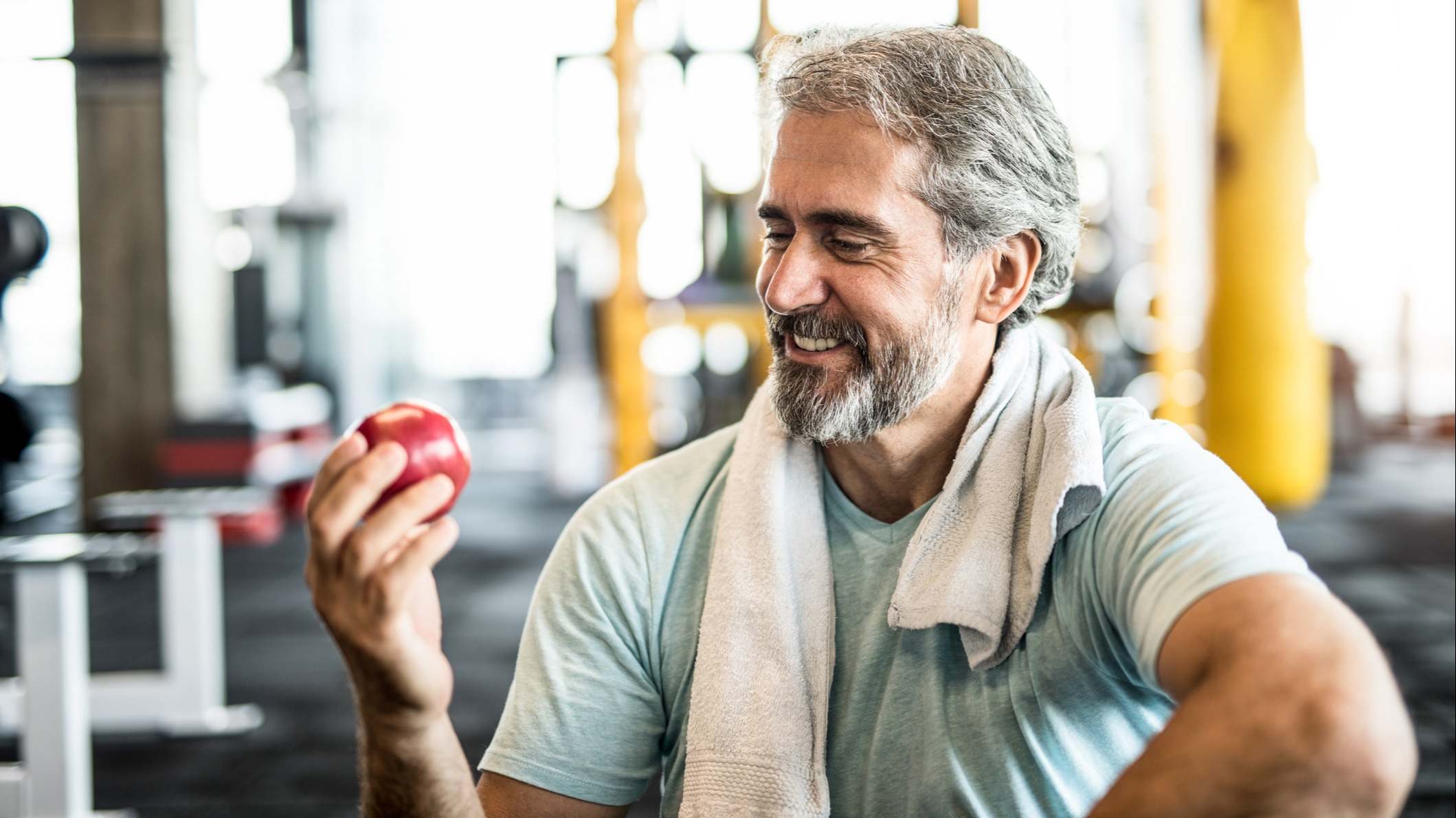 Hombre comiendo una manzana en un gimnasio
