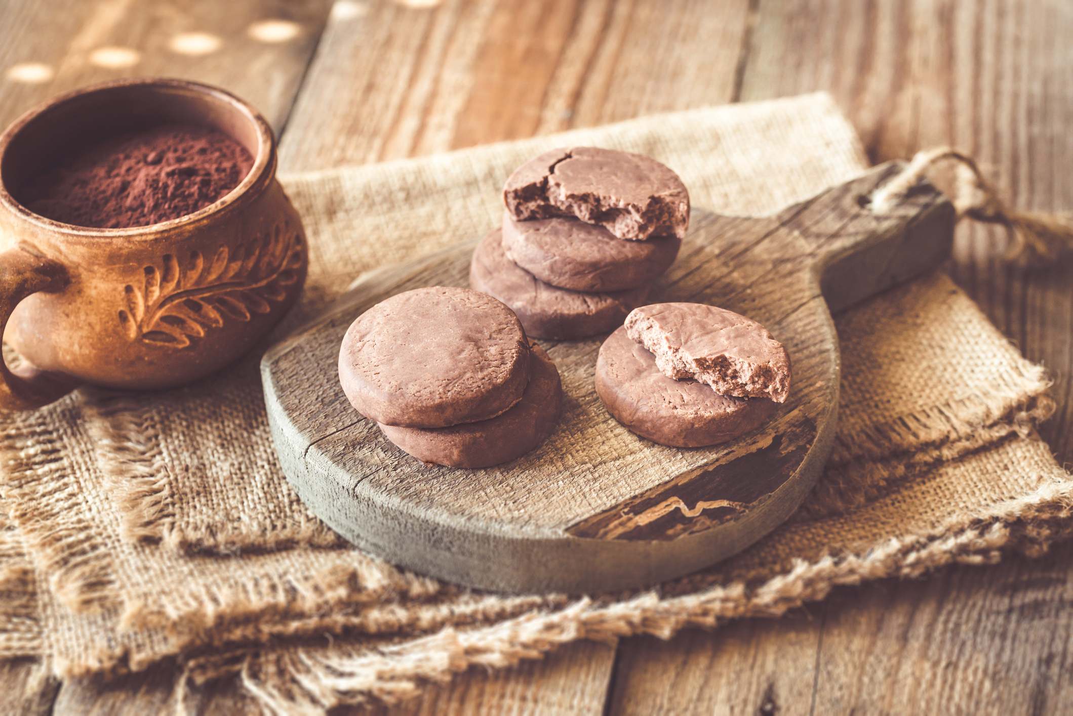 Polvorones en una bandeja de madera con un cazo de cacao