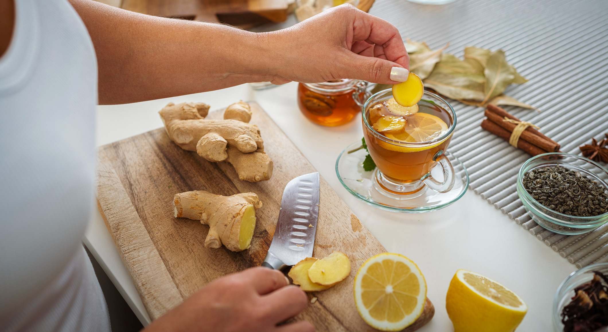 Mujer preparando té caliente de jengibre y limón