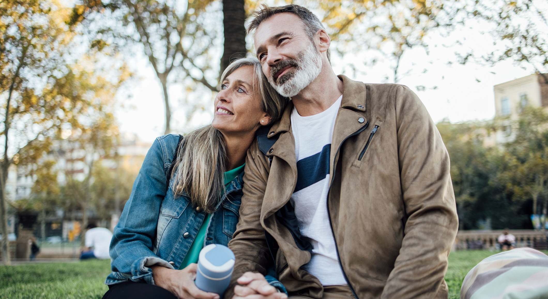 Pareja sentada en un parque dándose la mano