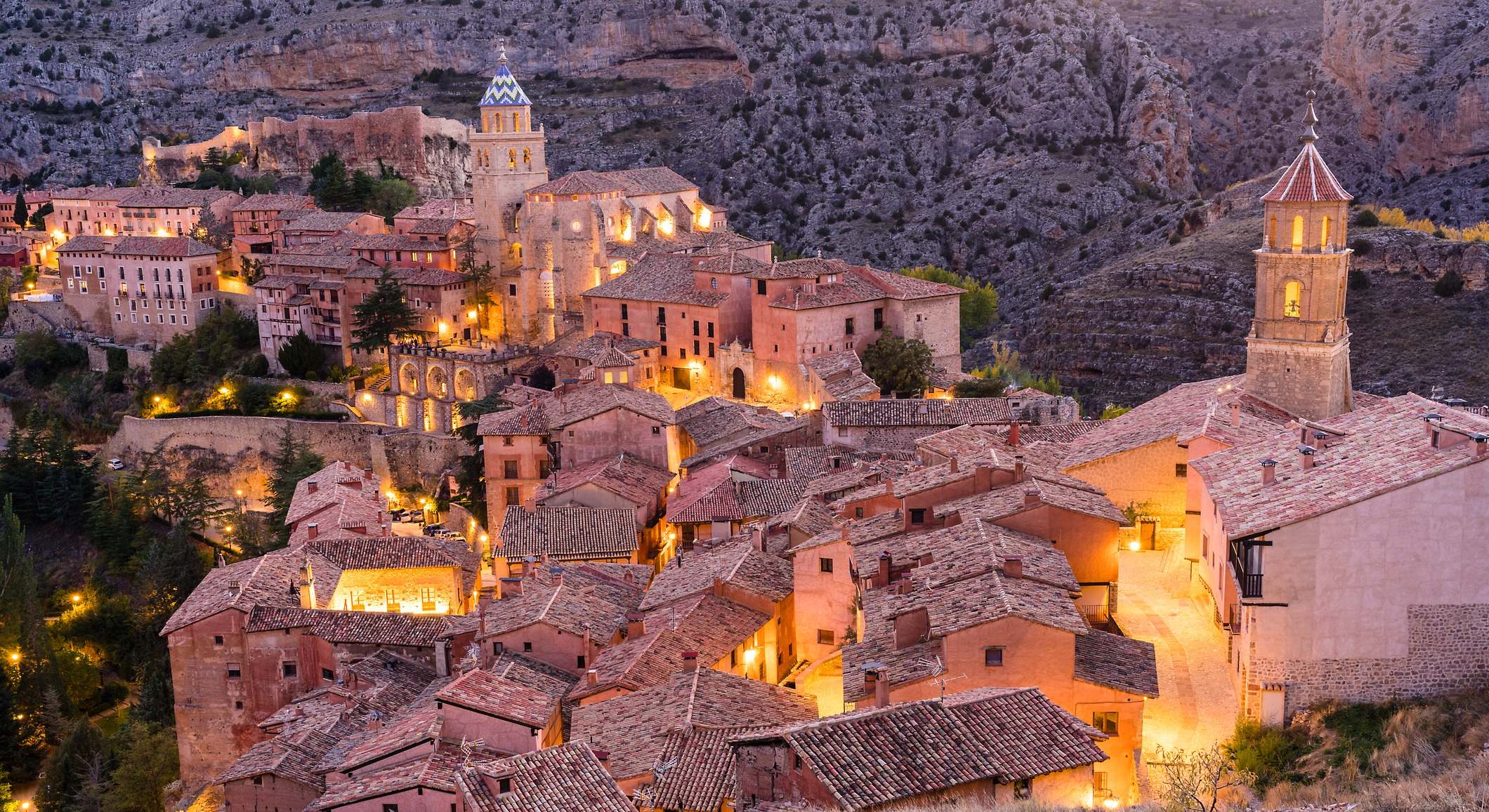 El Albarracín visto desde alto. Se puede ver todo el pueblo de un tono rojizo mientras la luz de las farolas rebota en sus paredes.