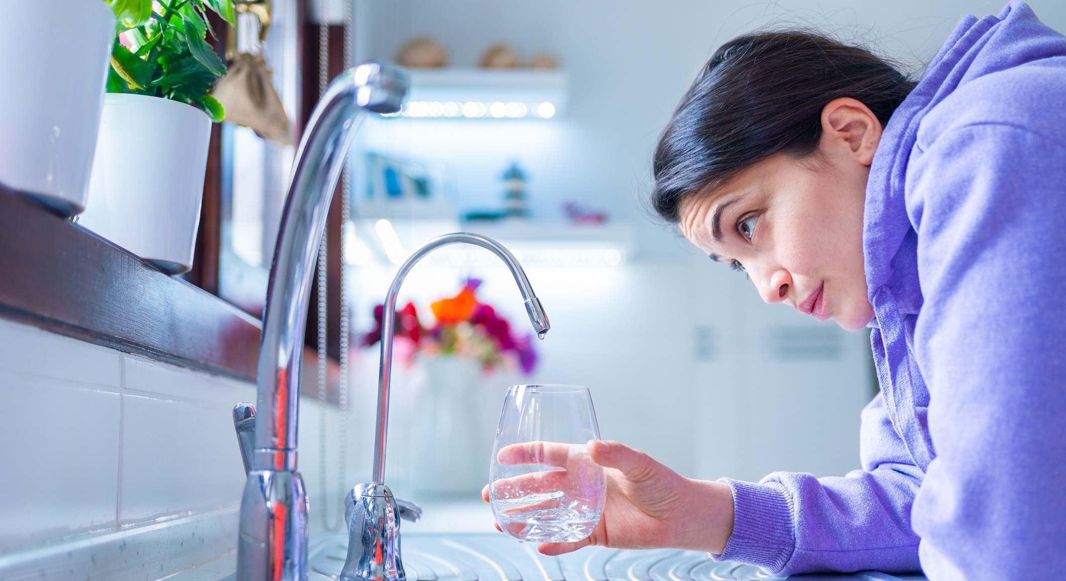 Chica cogiendo agua del grifo