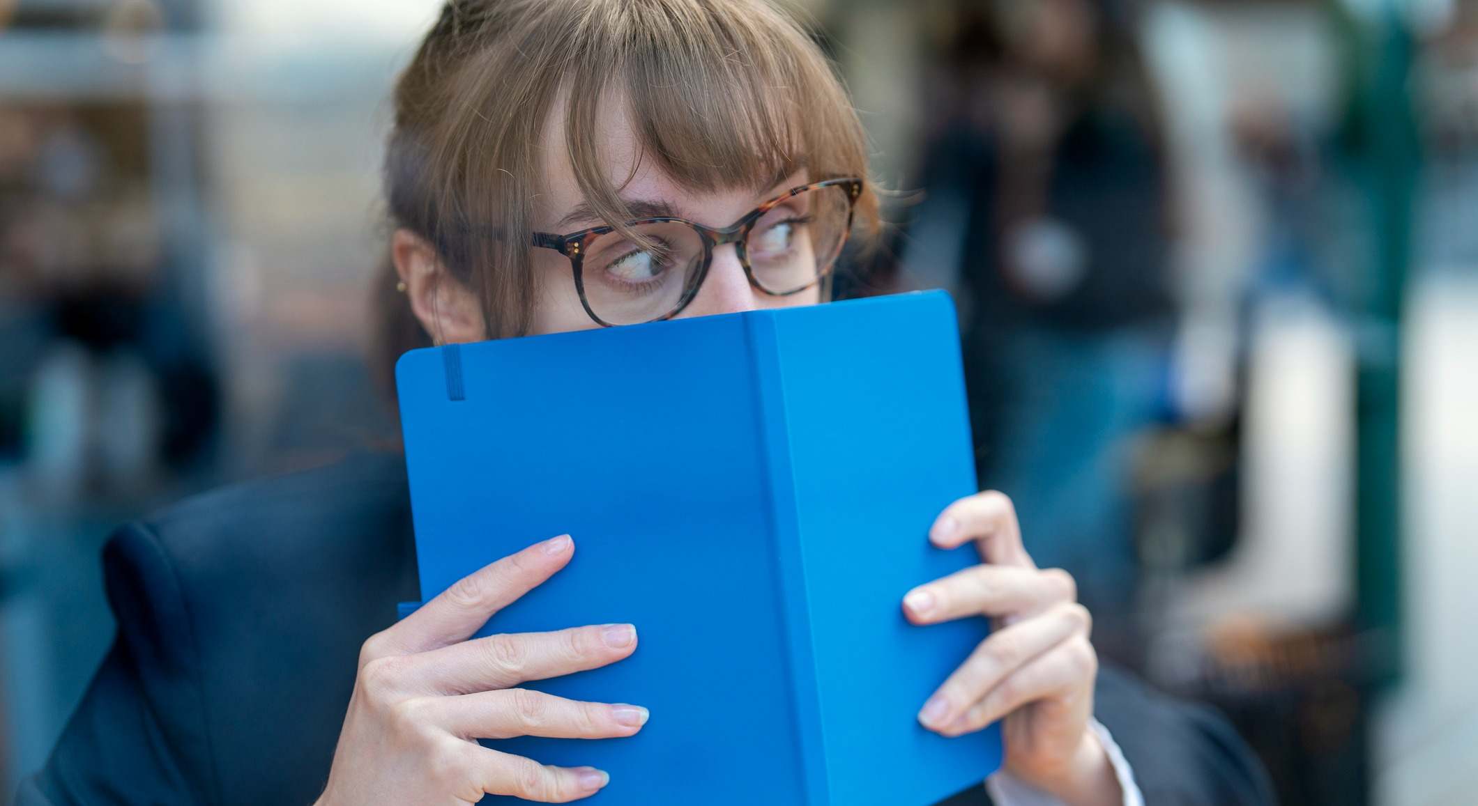 Mujer escondida tras un libro