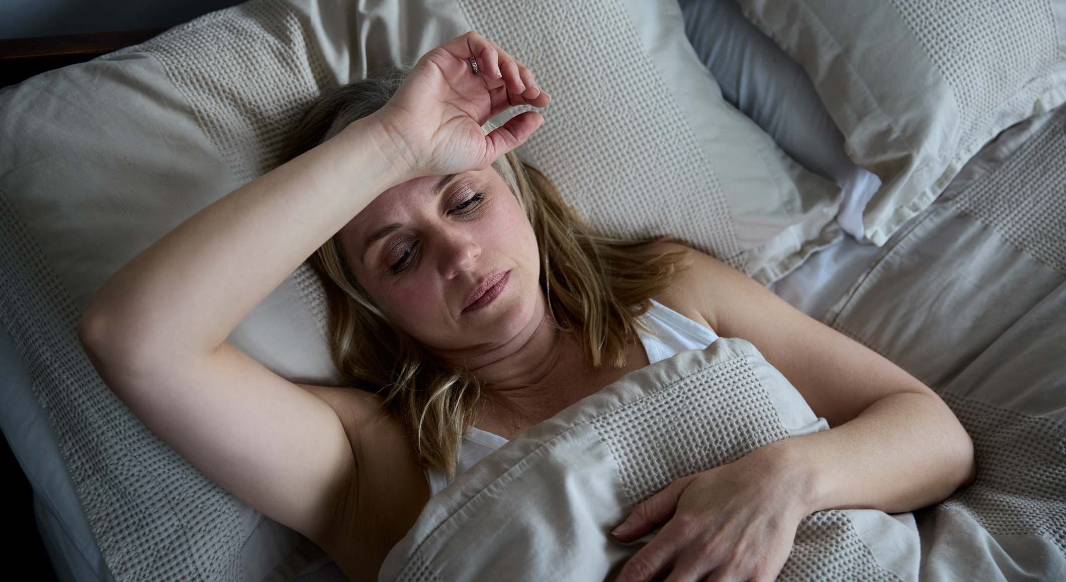 Mujer madura menopáusica que sufre de insomnio en la cama