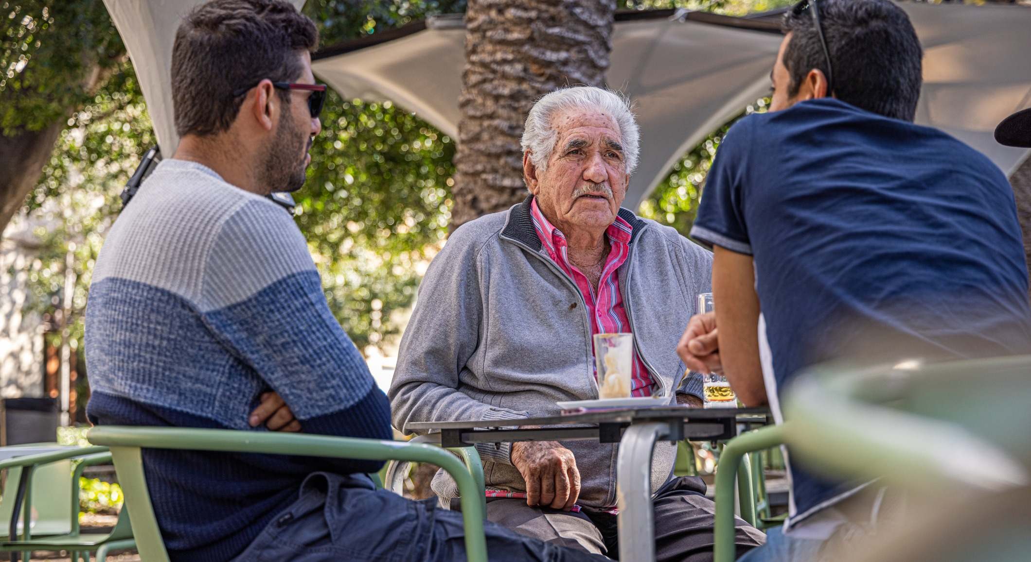 Un padre y sus dos hijos toman algo en una terraza. Foto: iStock