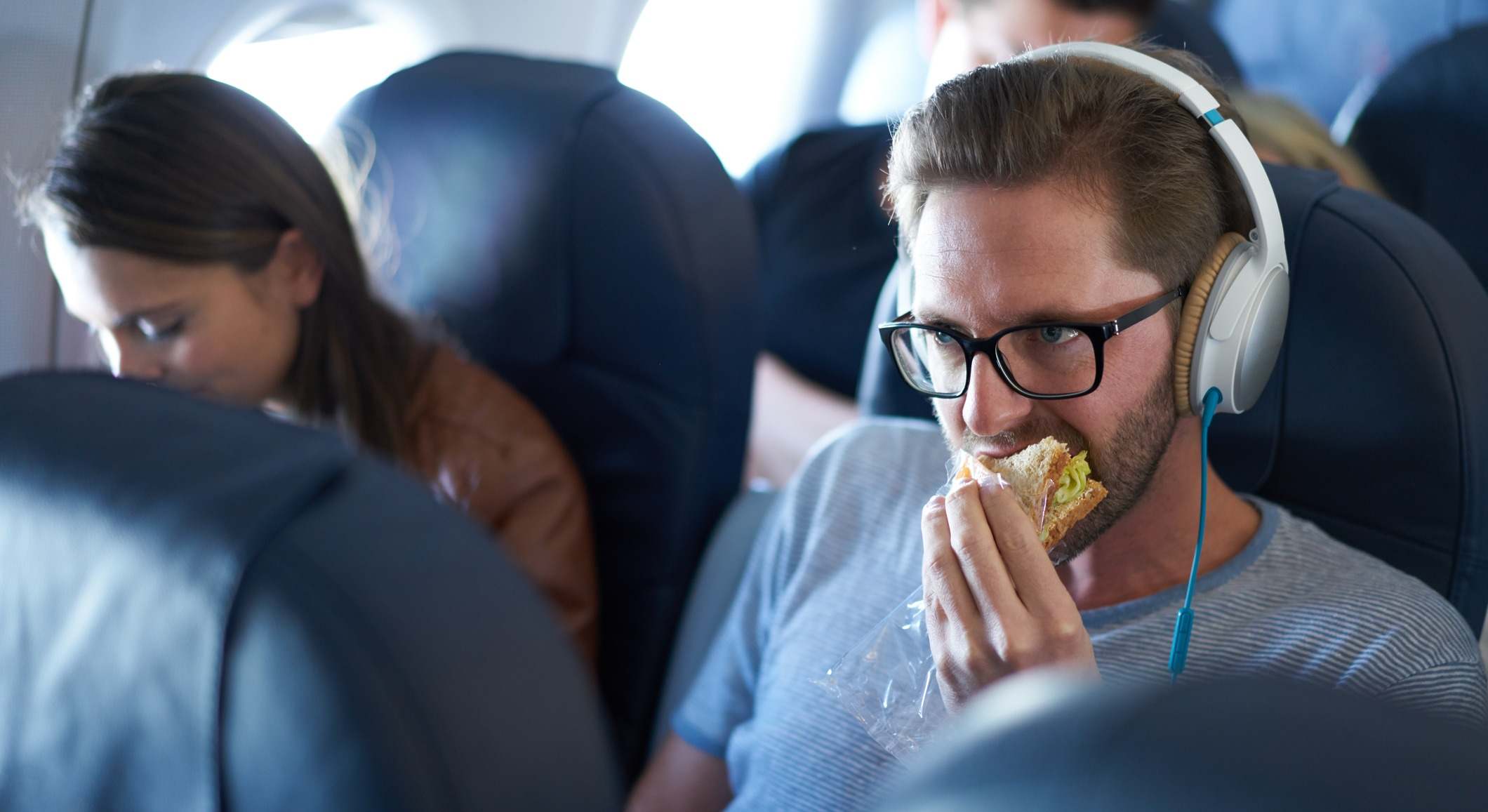 Un hombre comiendo dentro de la cabina del avión