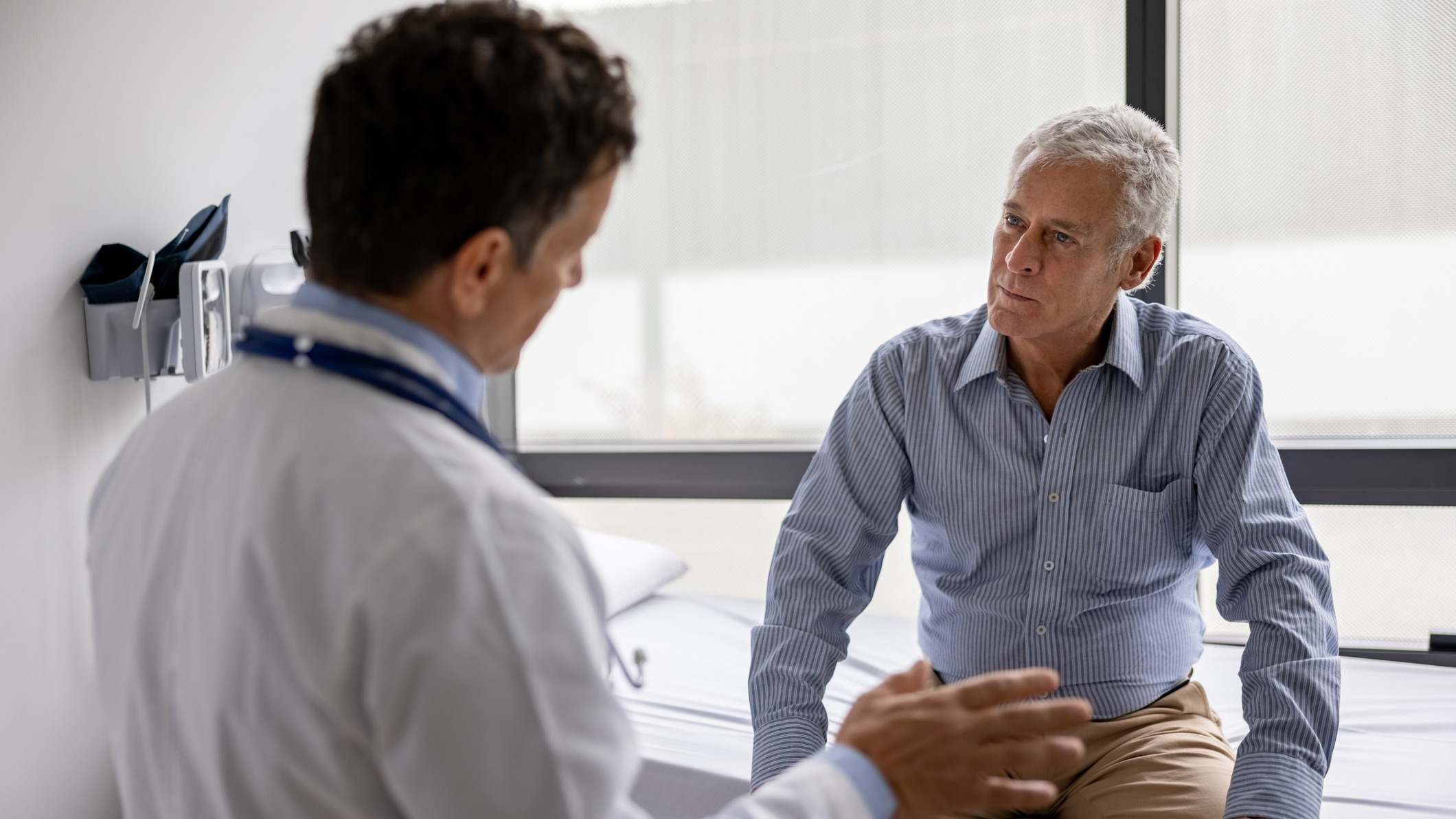 Médico hablando con un paciente en una consulta