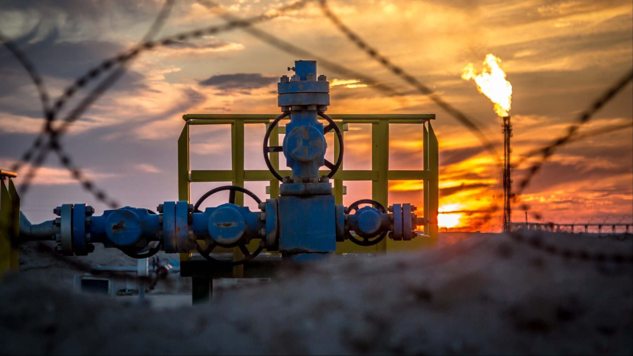 Una instalación petrolífera con el atardecer detrás