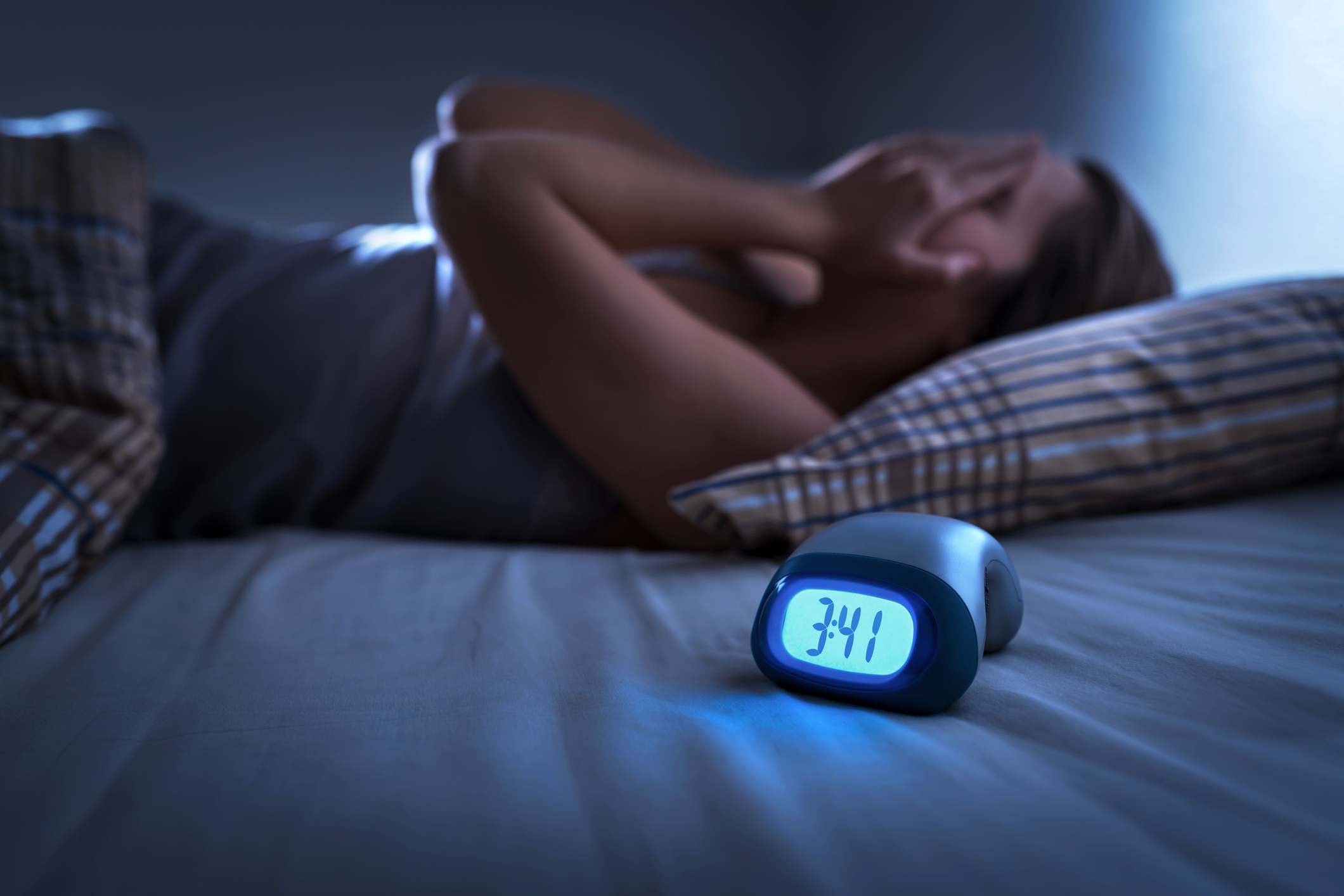 Mujer tumbada en la cama sin poder dormir a las 3:41 de la madrugada