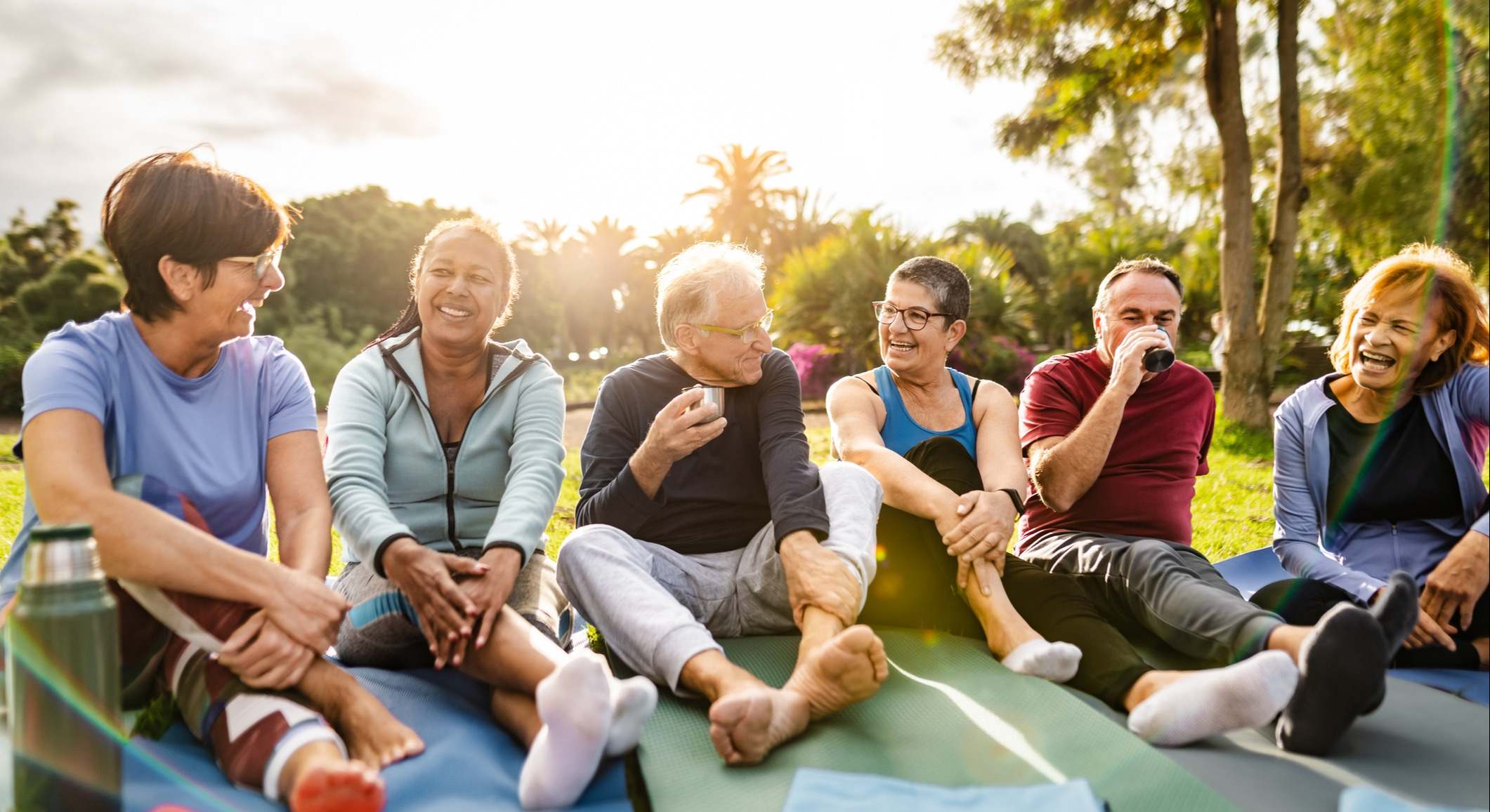 Personas mayores disfrutando de un té mientras hacen actividades en un parque