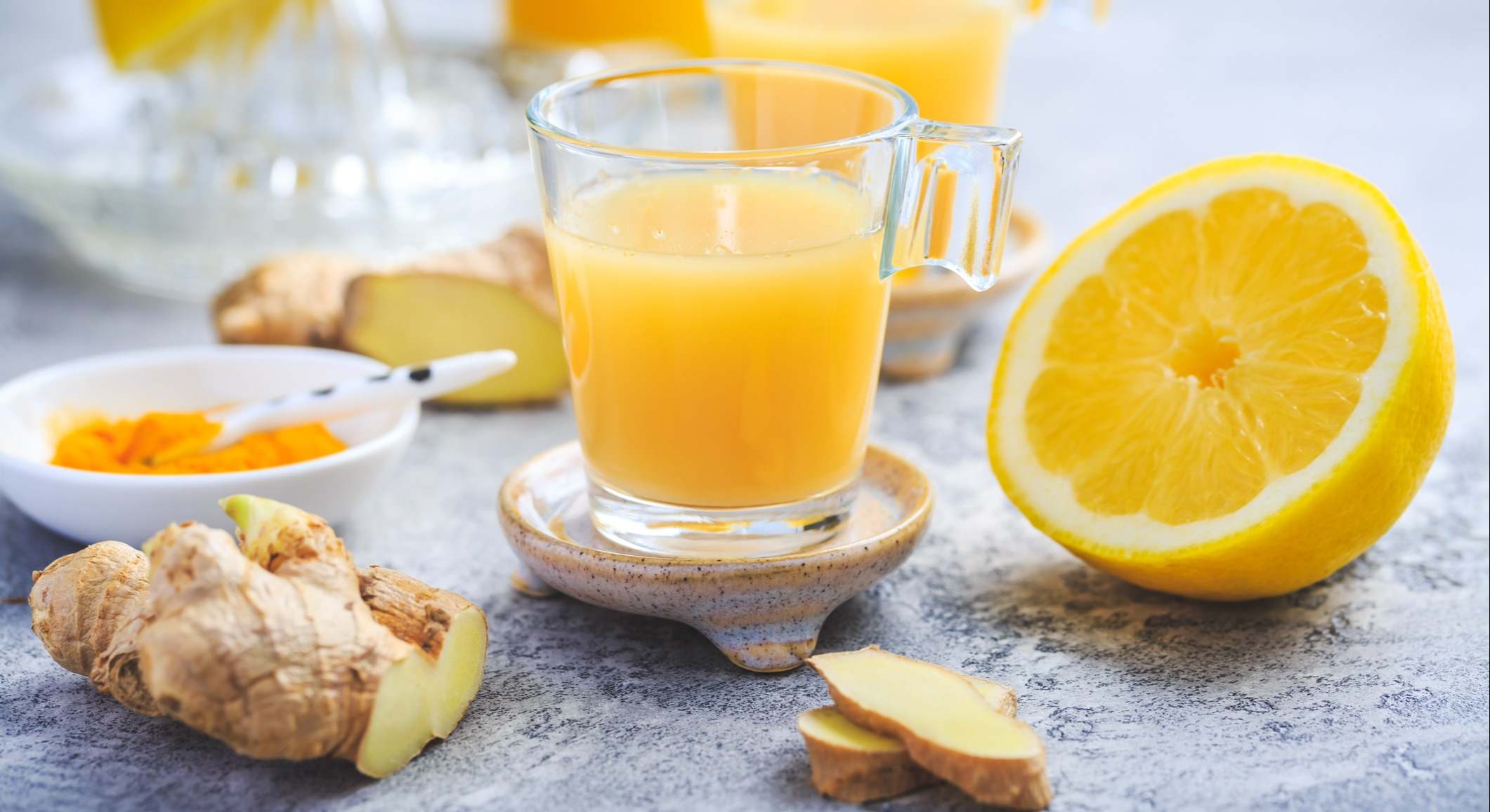 Zumo de naranja con una naranja, jengibre y cúrcuma de fondo