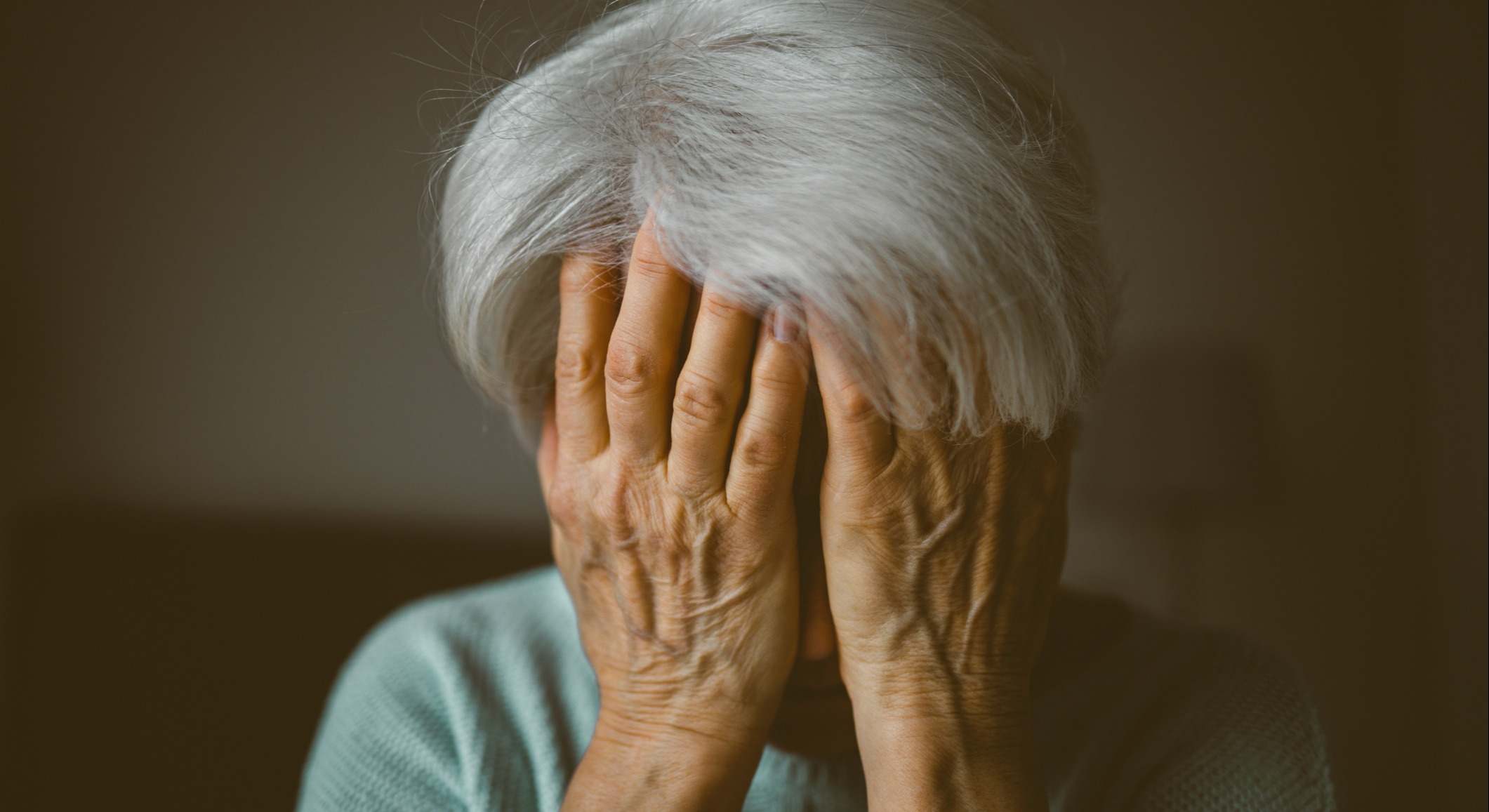 Una mujer mayor se cubre la cara con las manos