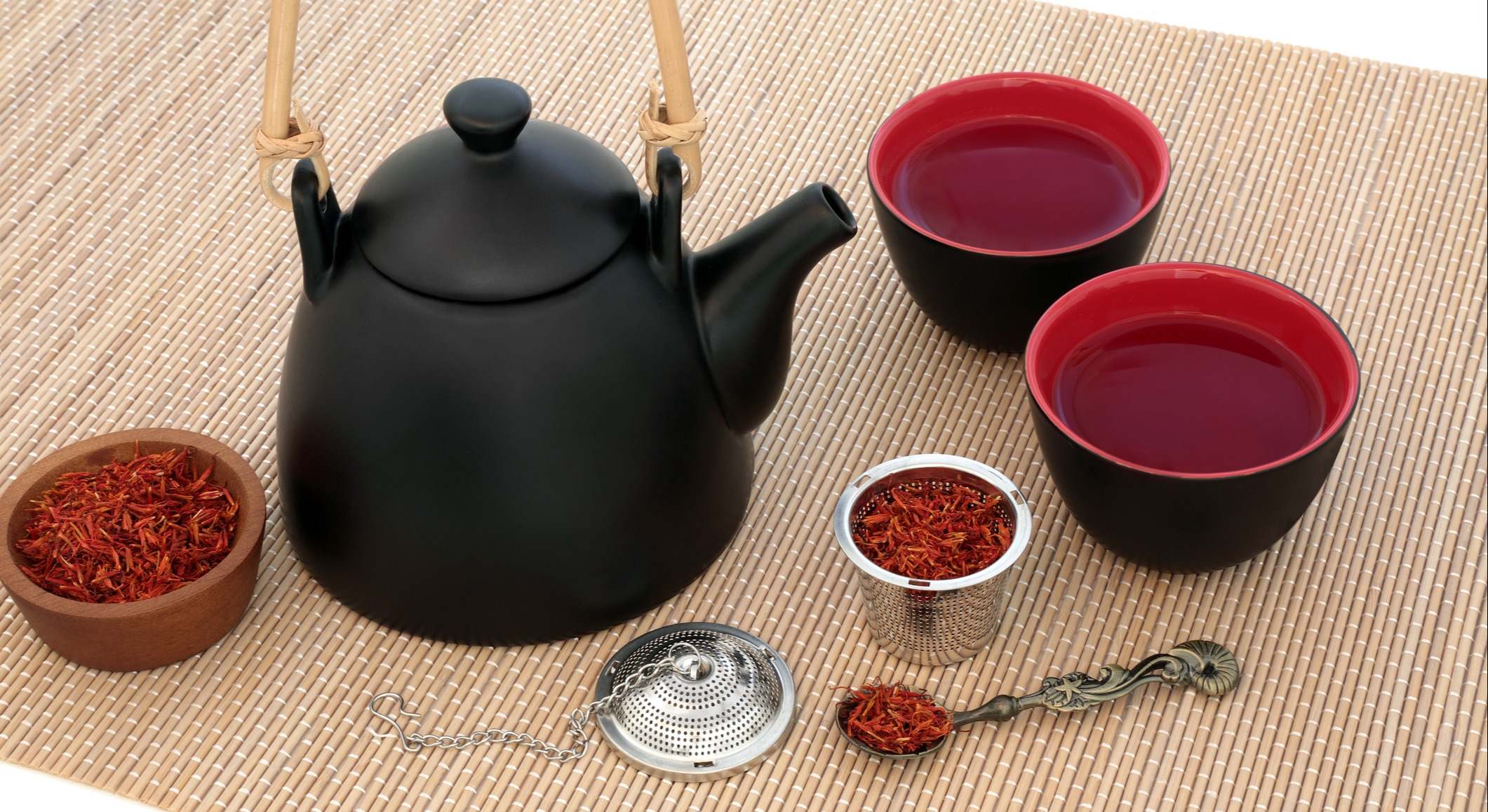 Una tetera con dos vasos rellenos de infusión de azafrán