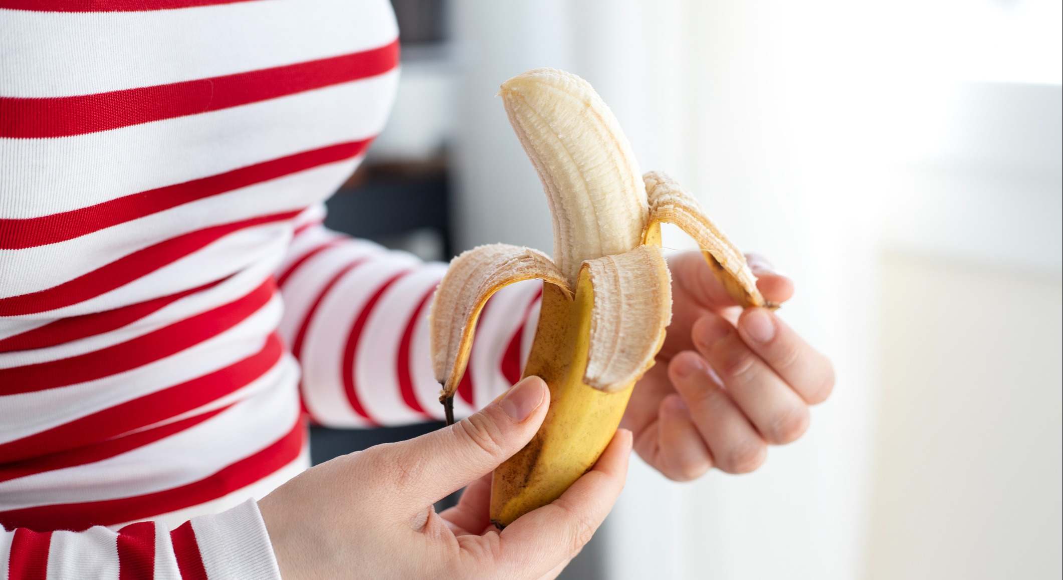 Mujer sosteniendo un plátano en sus manos