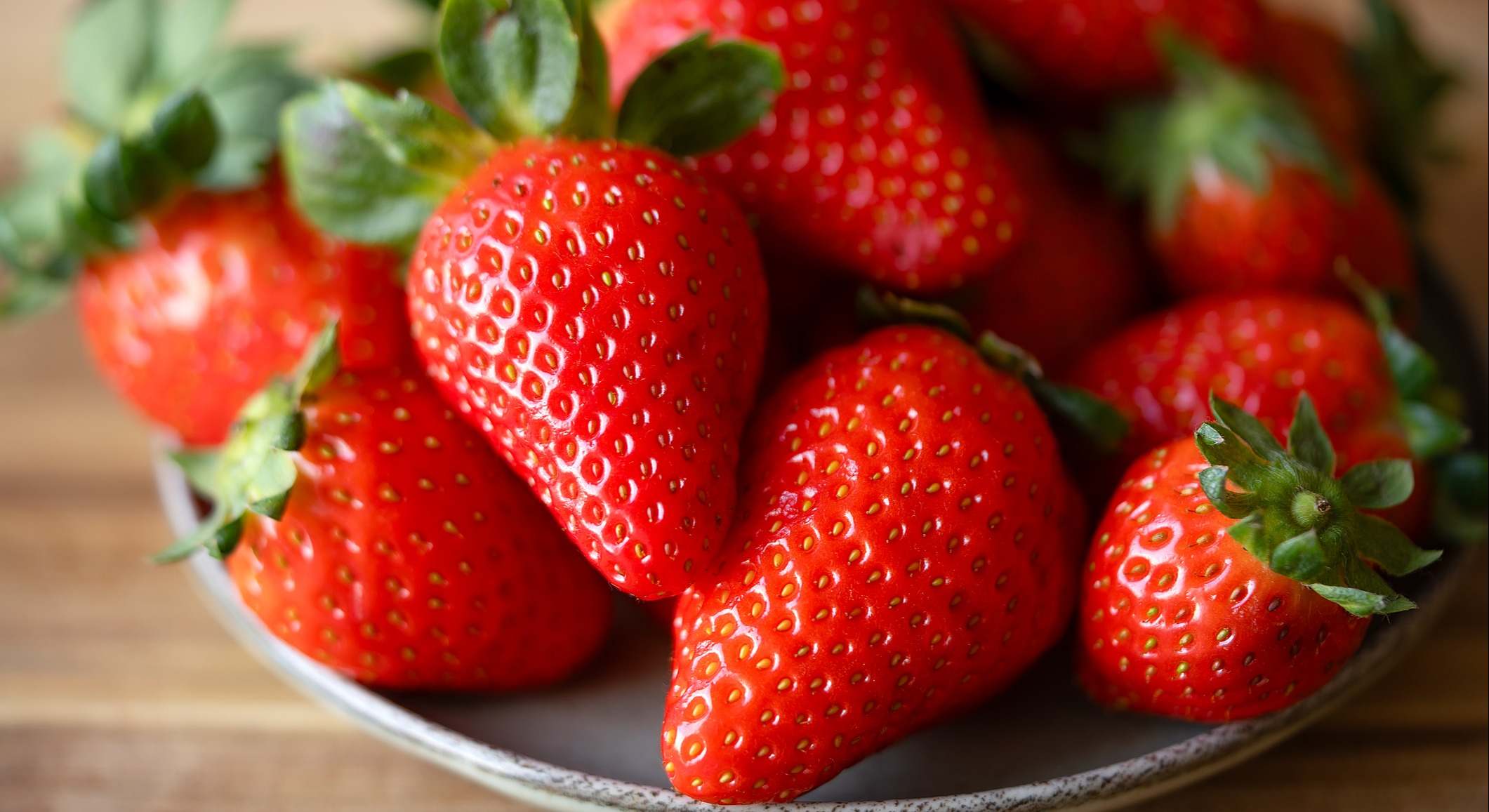 Fresas en un plato sobre una mesa de madera