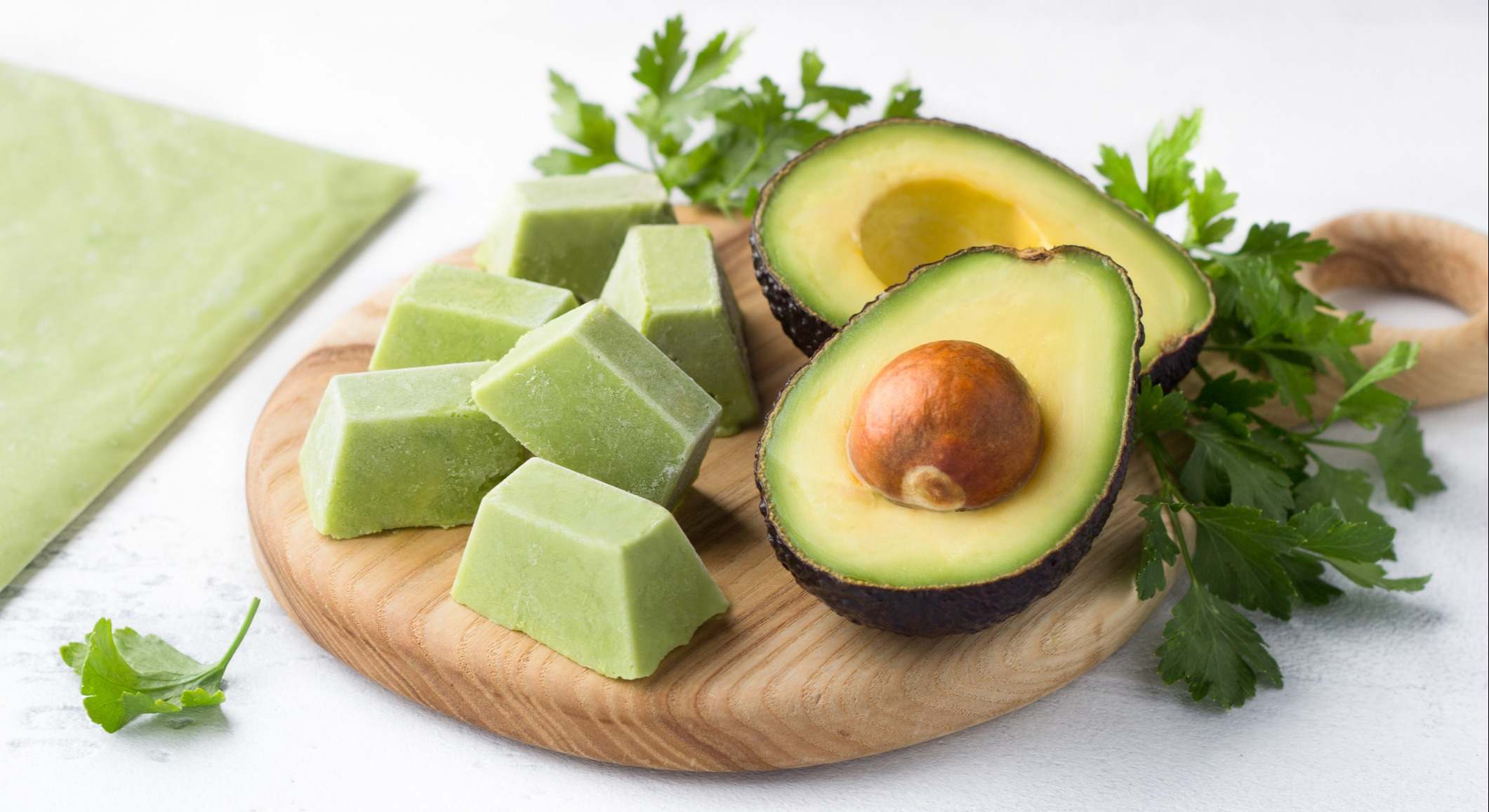 Aguacate abierto por la mitad sobre una tabla de madera