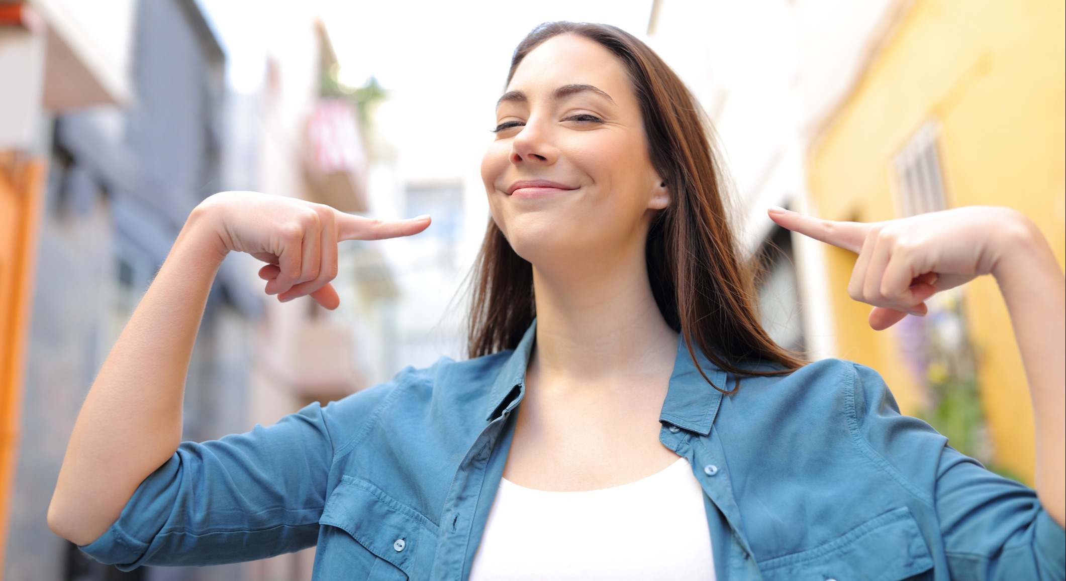 Mujer orgullosa señalando a sí misma en la calle