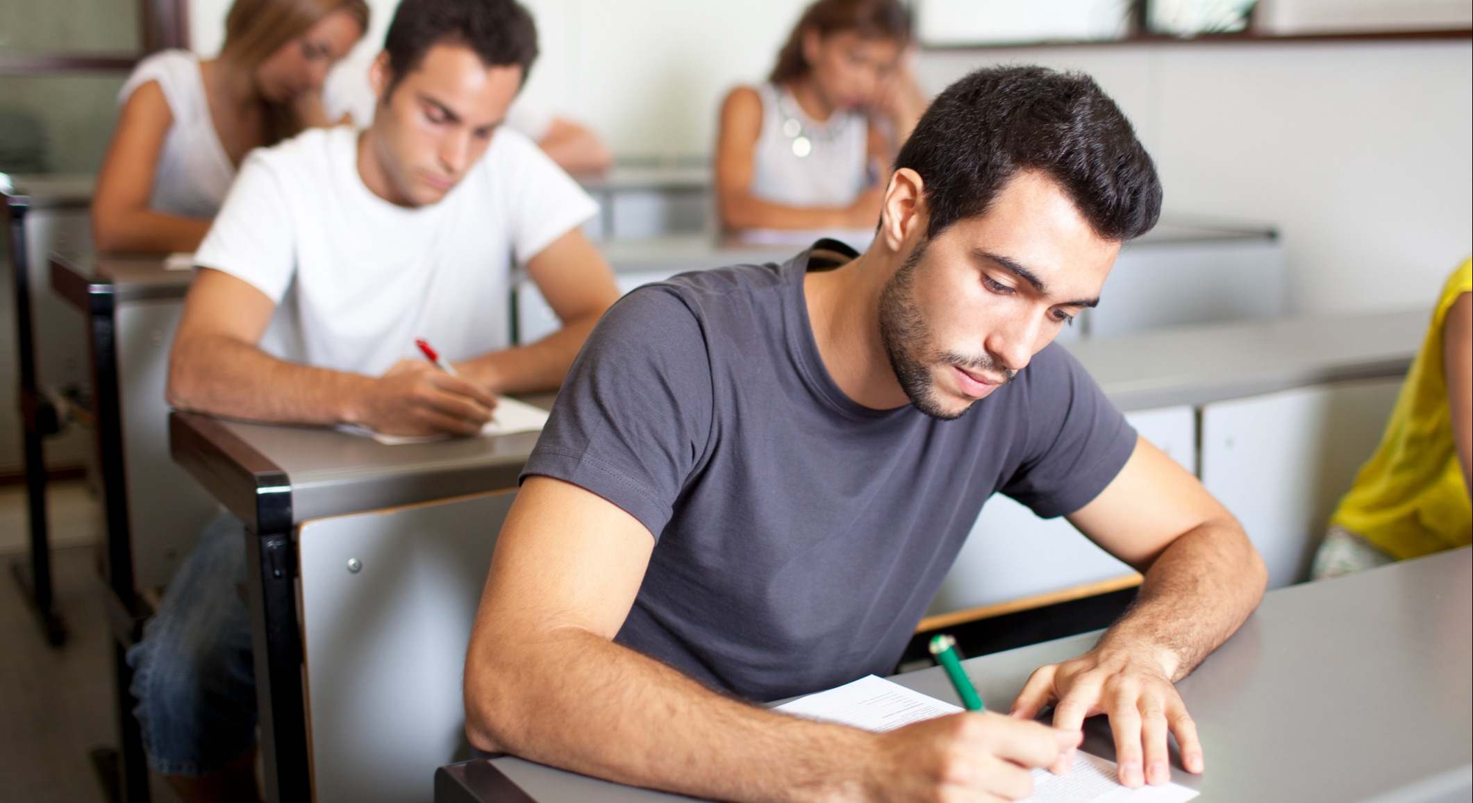 Grupo de jóvenes haciendo un examen en un aula