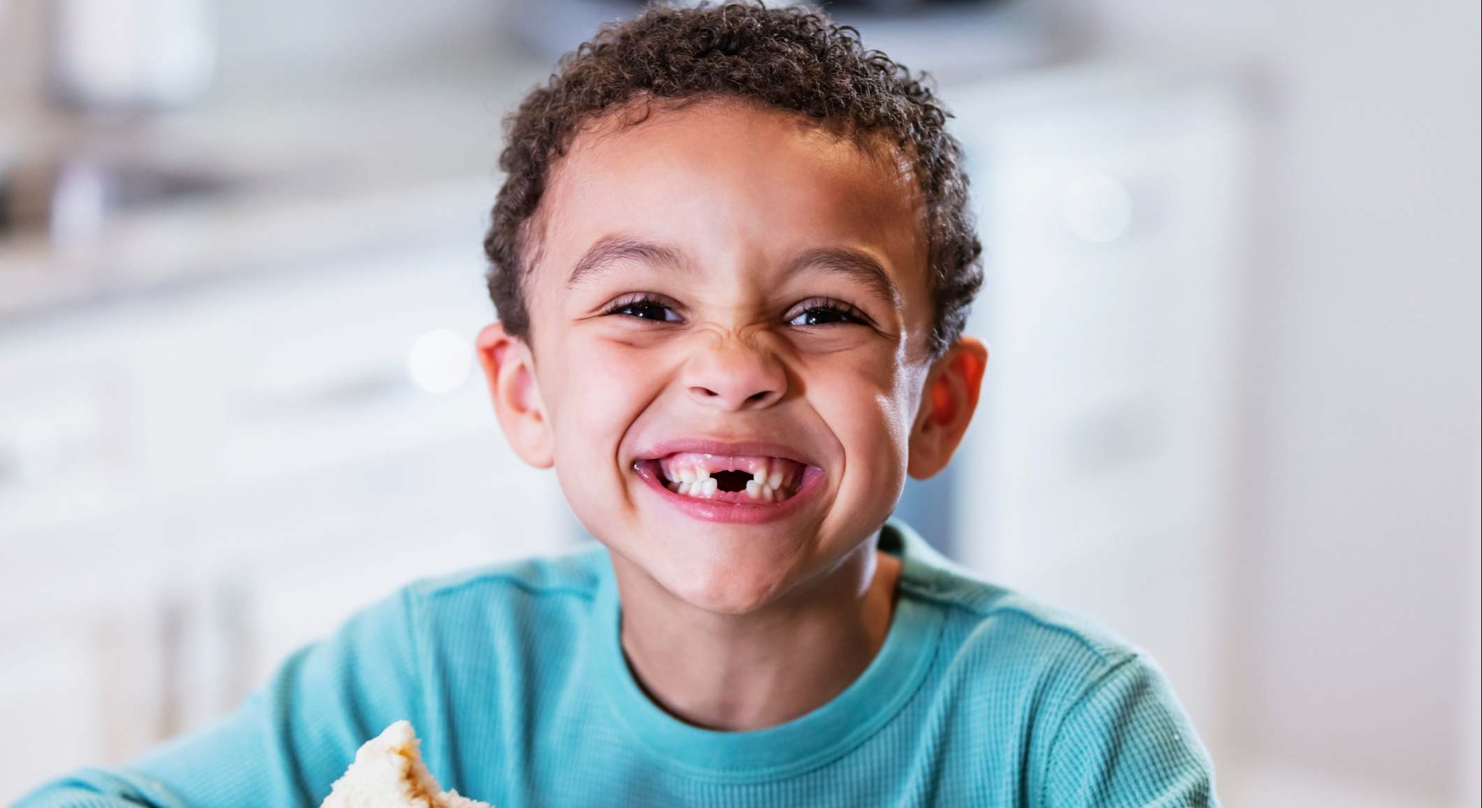 Niño comiendo un sandwich de mantequilla de cacahuete