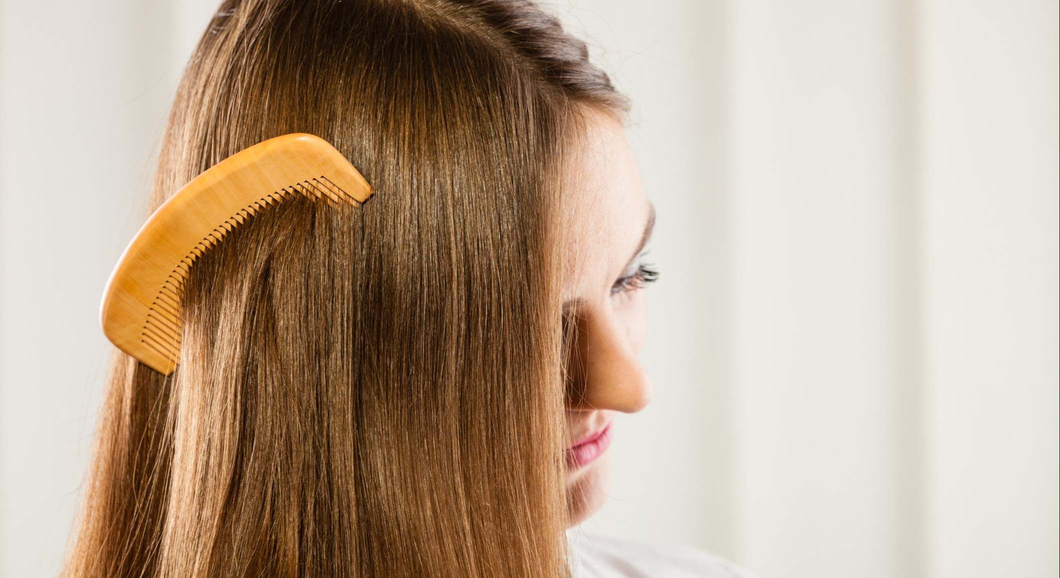 Mujer con el pelo liso con un peine en el cabello