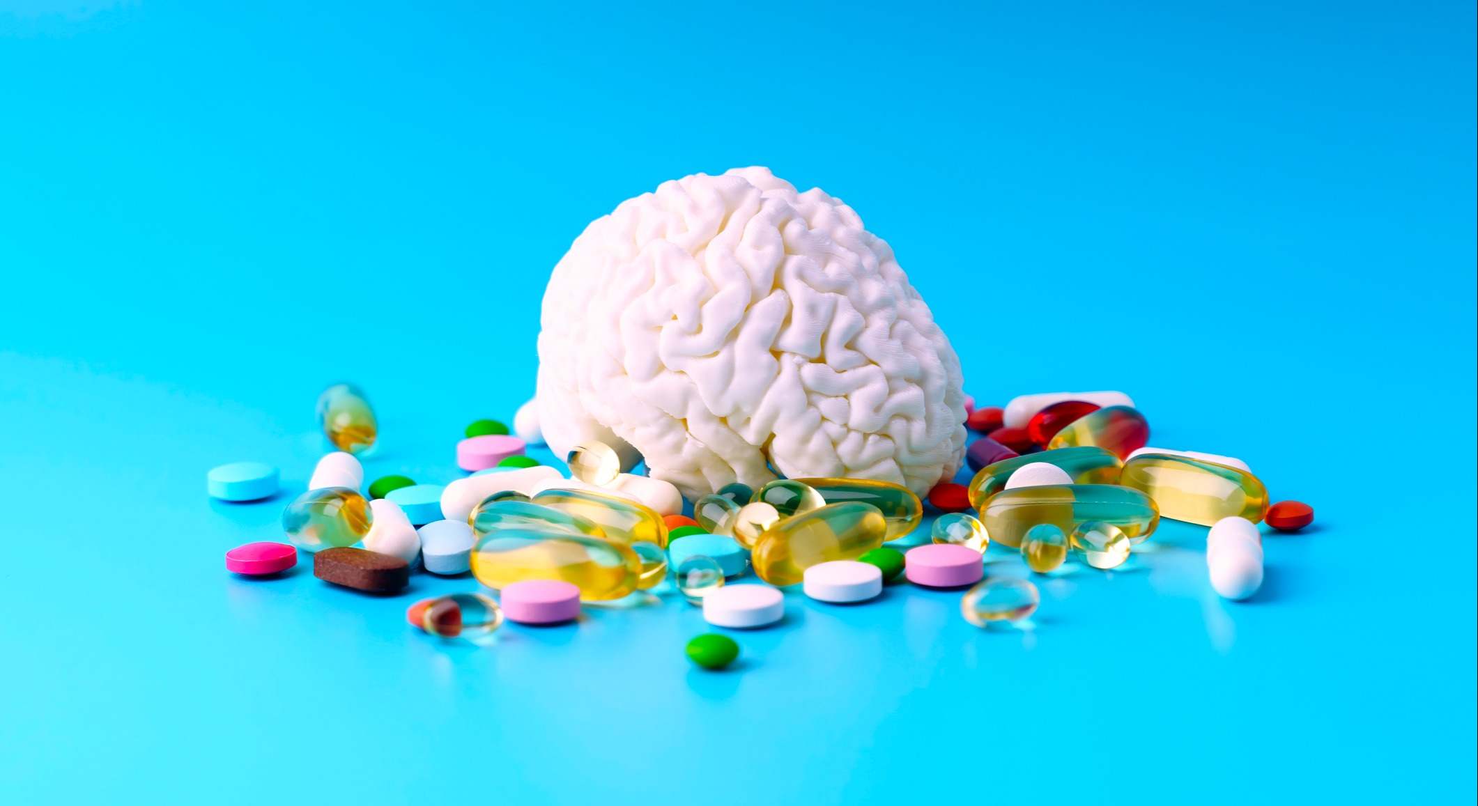 Cerebro rodeado por píldoras y pastillas de vitaminas