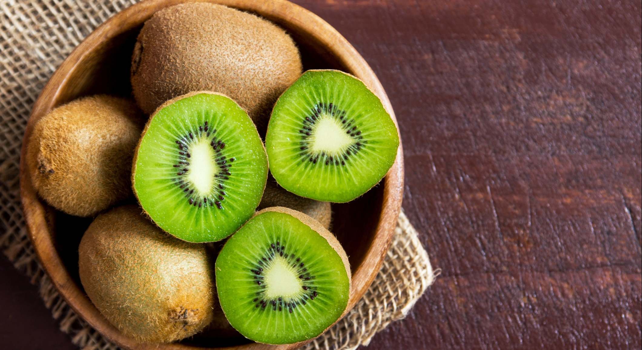 Cuenco de kiwis sobre una mesa de madera
