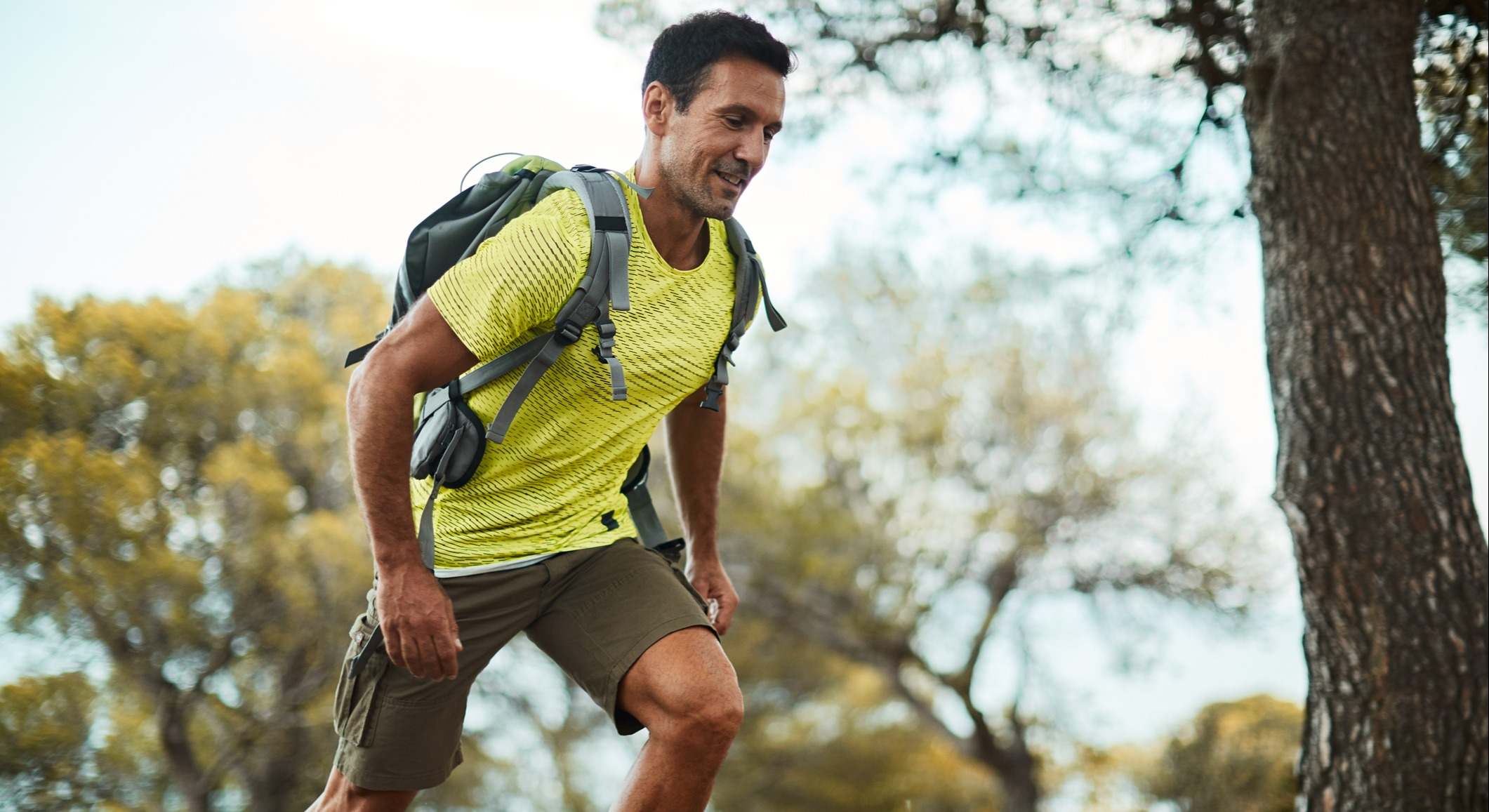Hombre corriendo con una mochila por el bosque