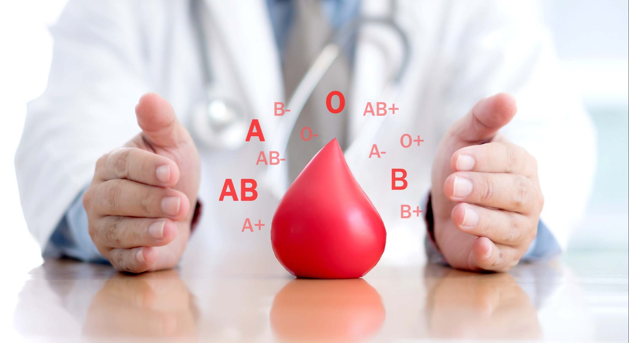 Médico en una consulta con una gota de sangre hecha en 3D con los distintos grupos sanguíneos