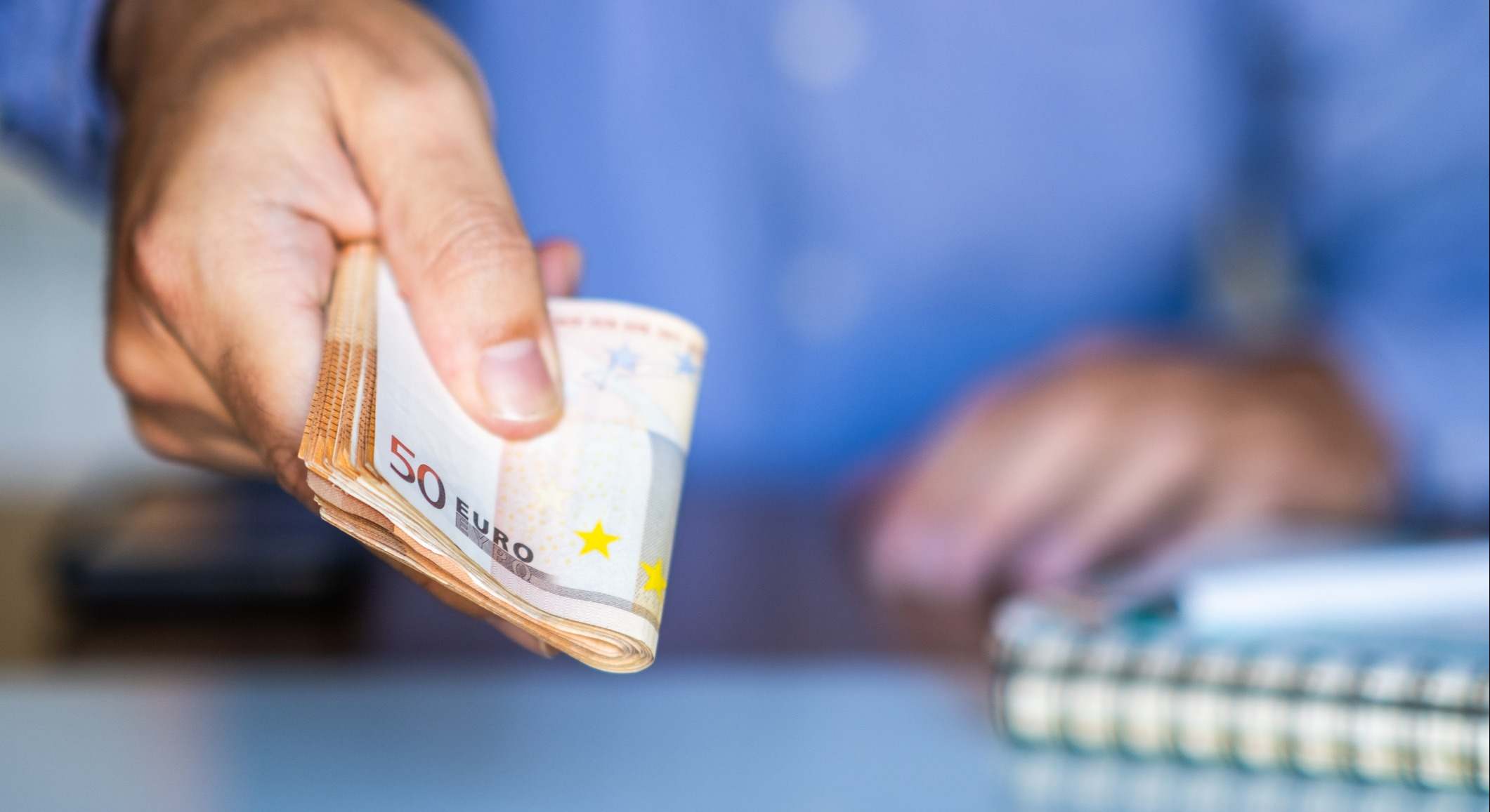 Una mano sujeta billetes de euro