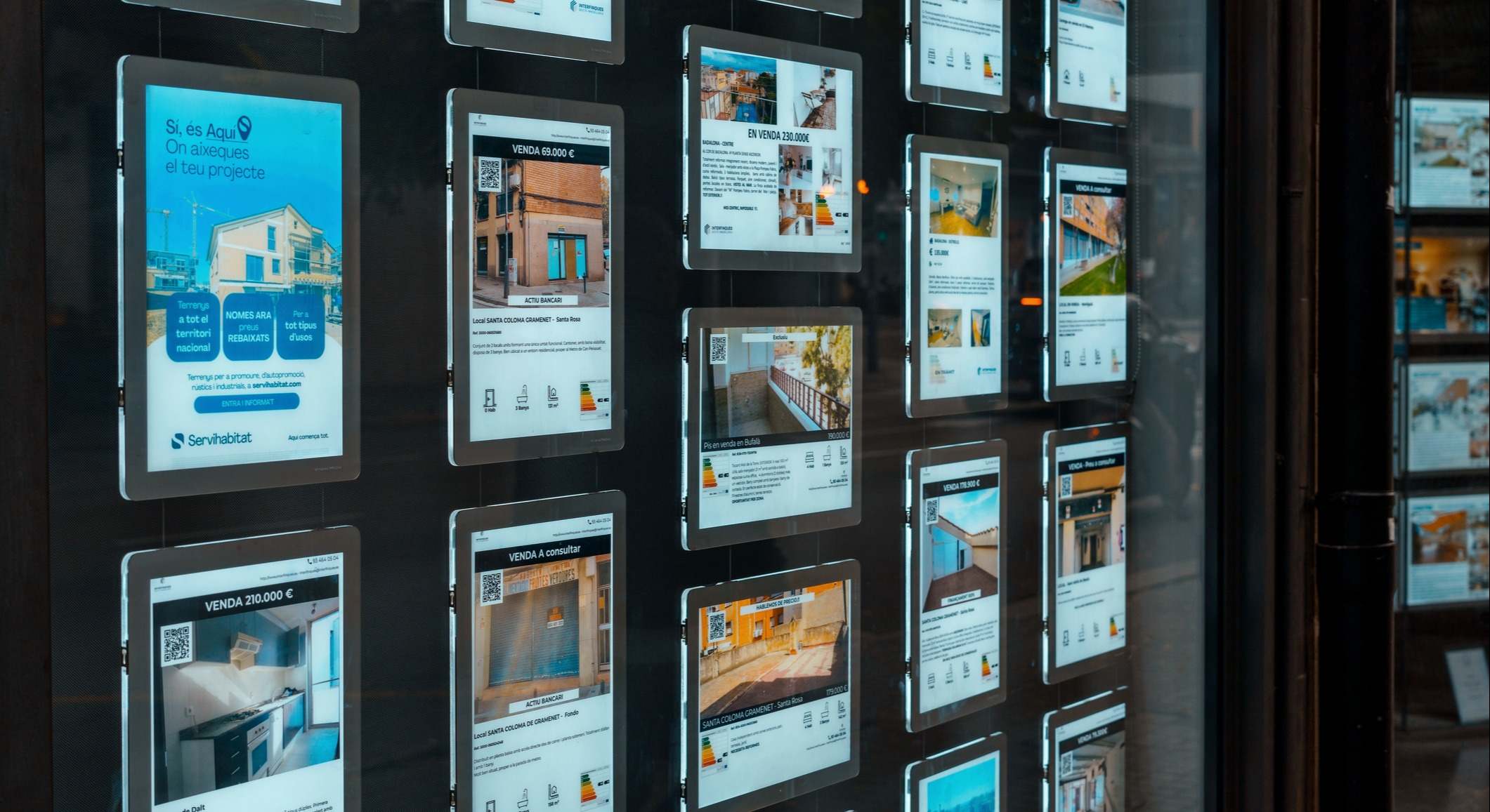 Escaparate de una agencia inmobiliaria con anuncios de pisos en venta o alquiler. Concepto de aumento de los tipos de interés hipotecarios