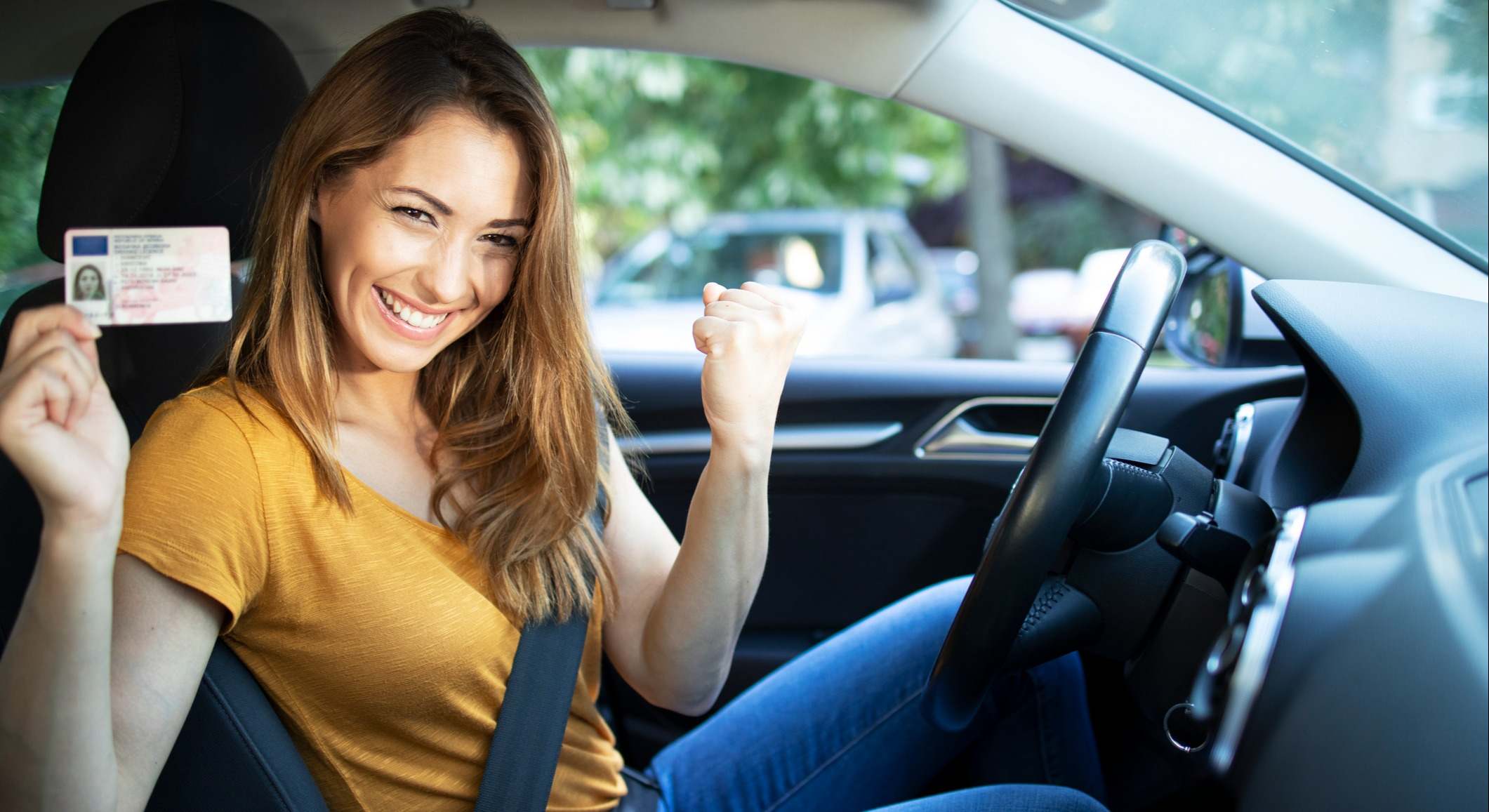 Mujer con un carnet de conducir en un coche