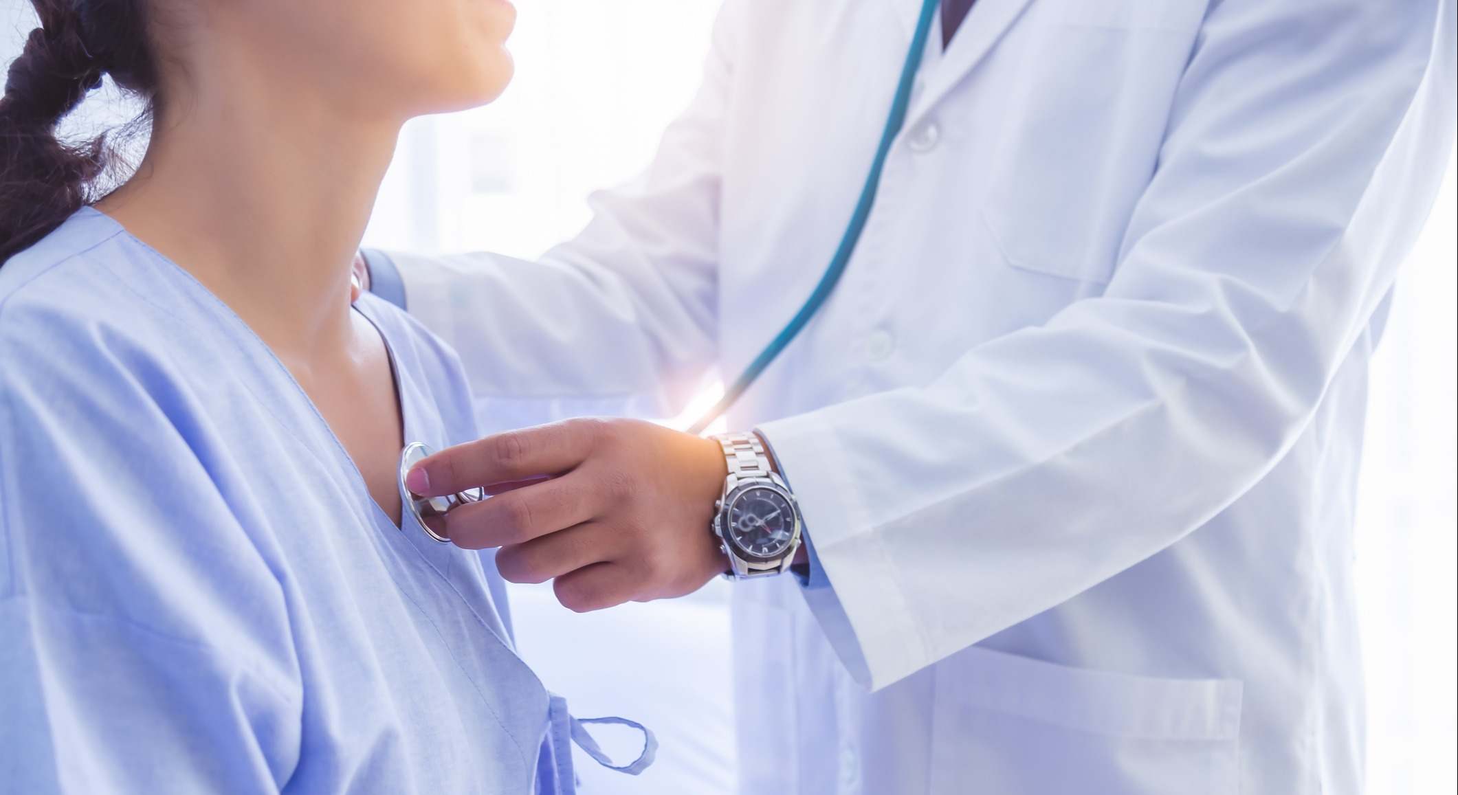 Médico usa estetoscopio para revisar el latido del corazón de una paciente