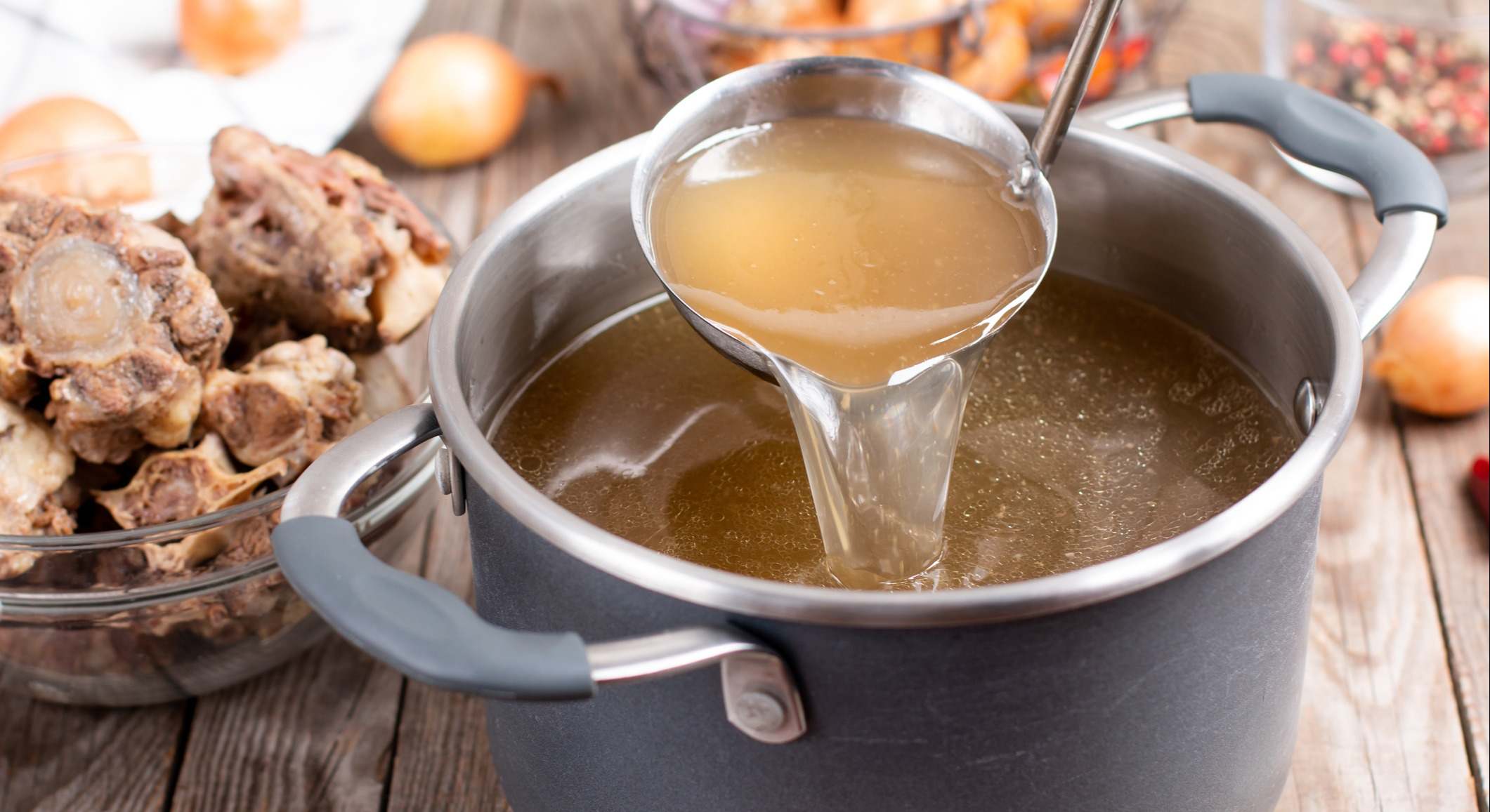 Olla de caldo sobre una mesa de madera