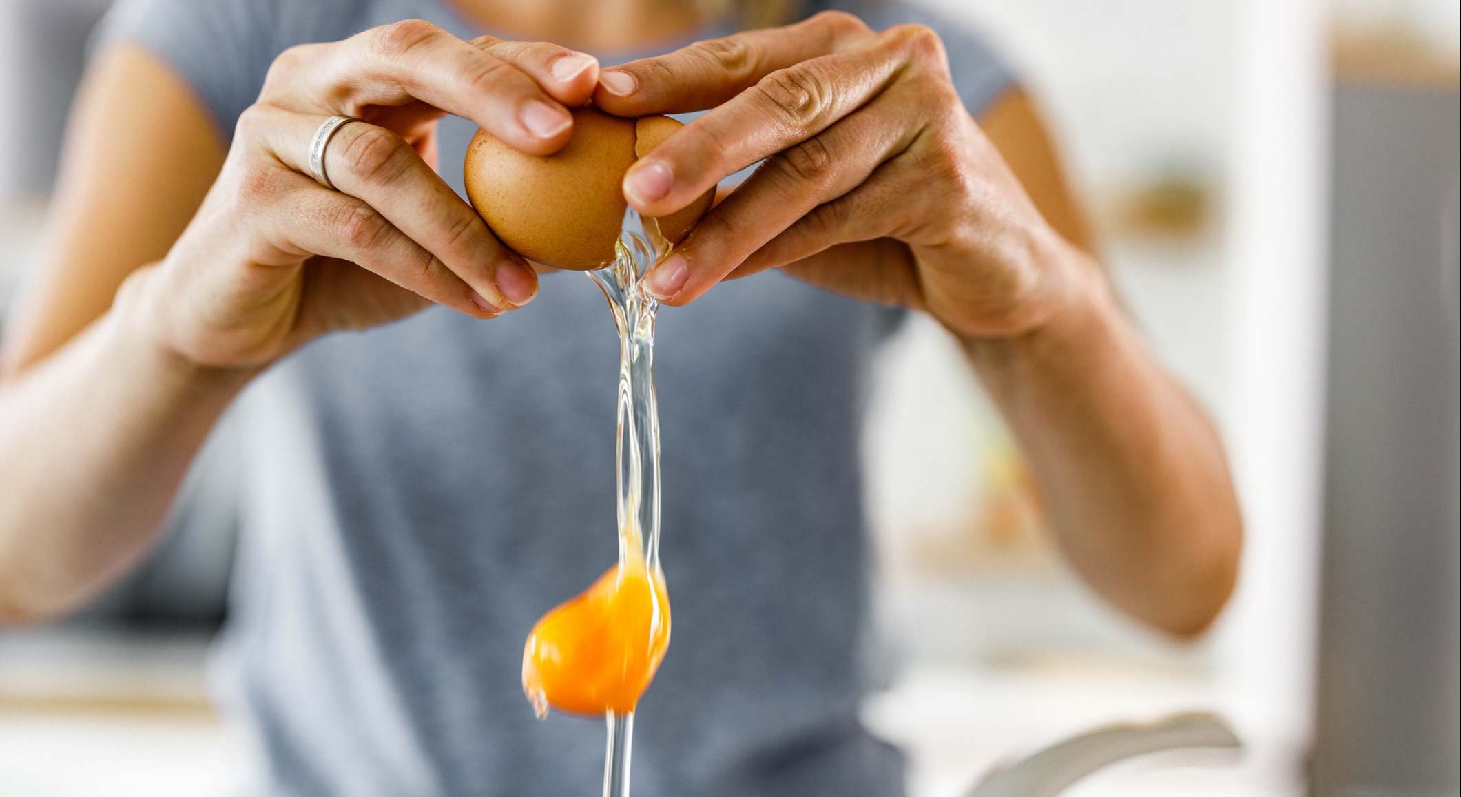 Mujer rompiendo un huevo para cocinar