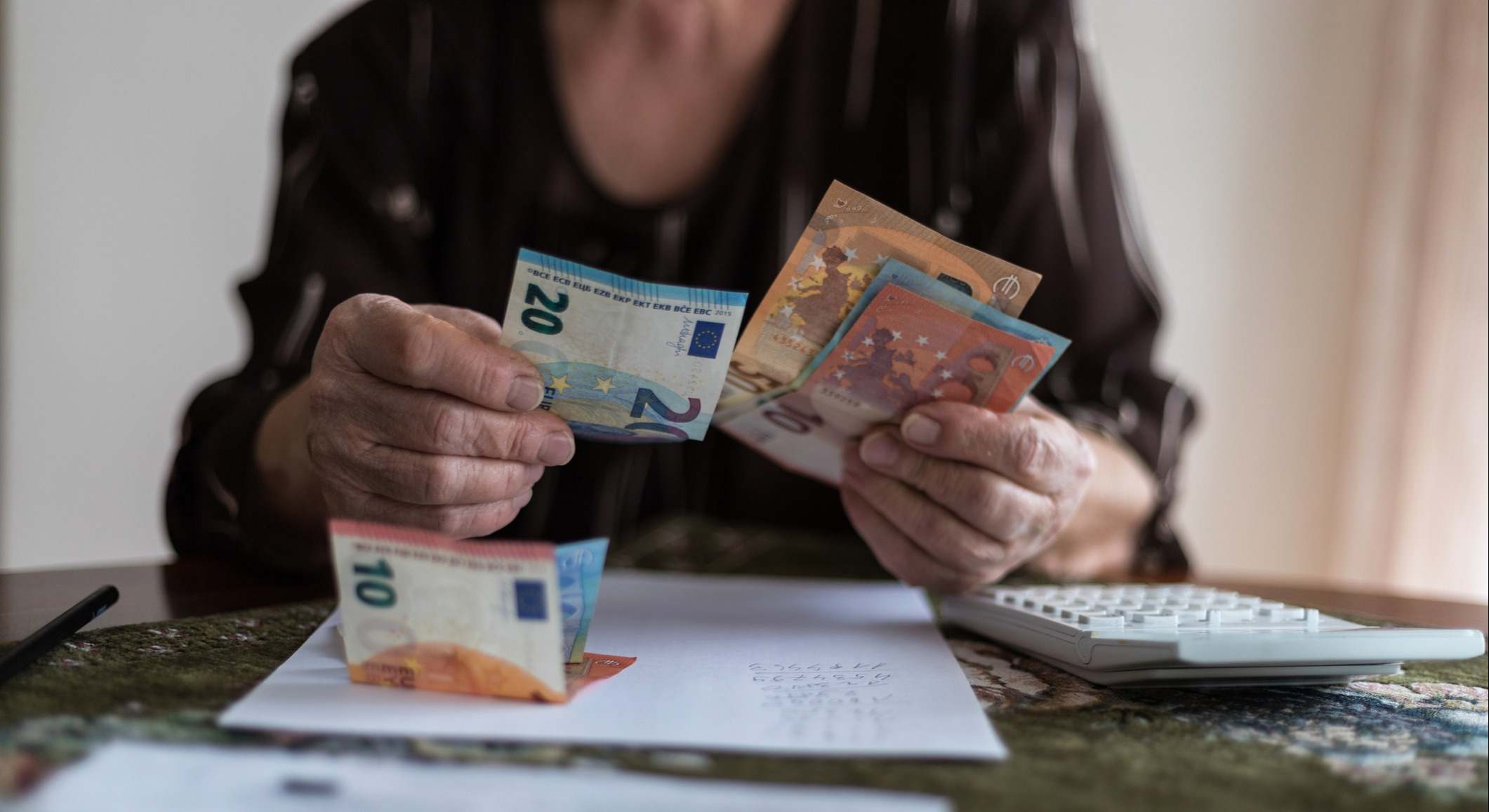 Una persona mayor contando billetes de euro