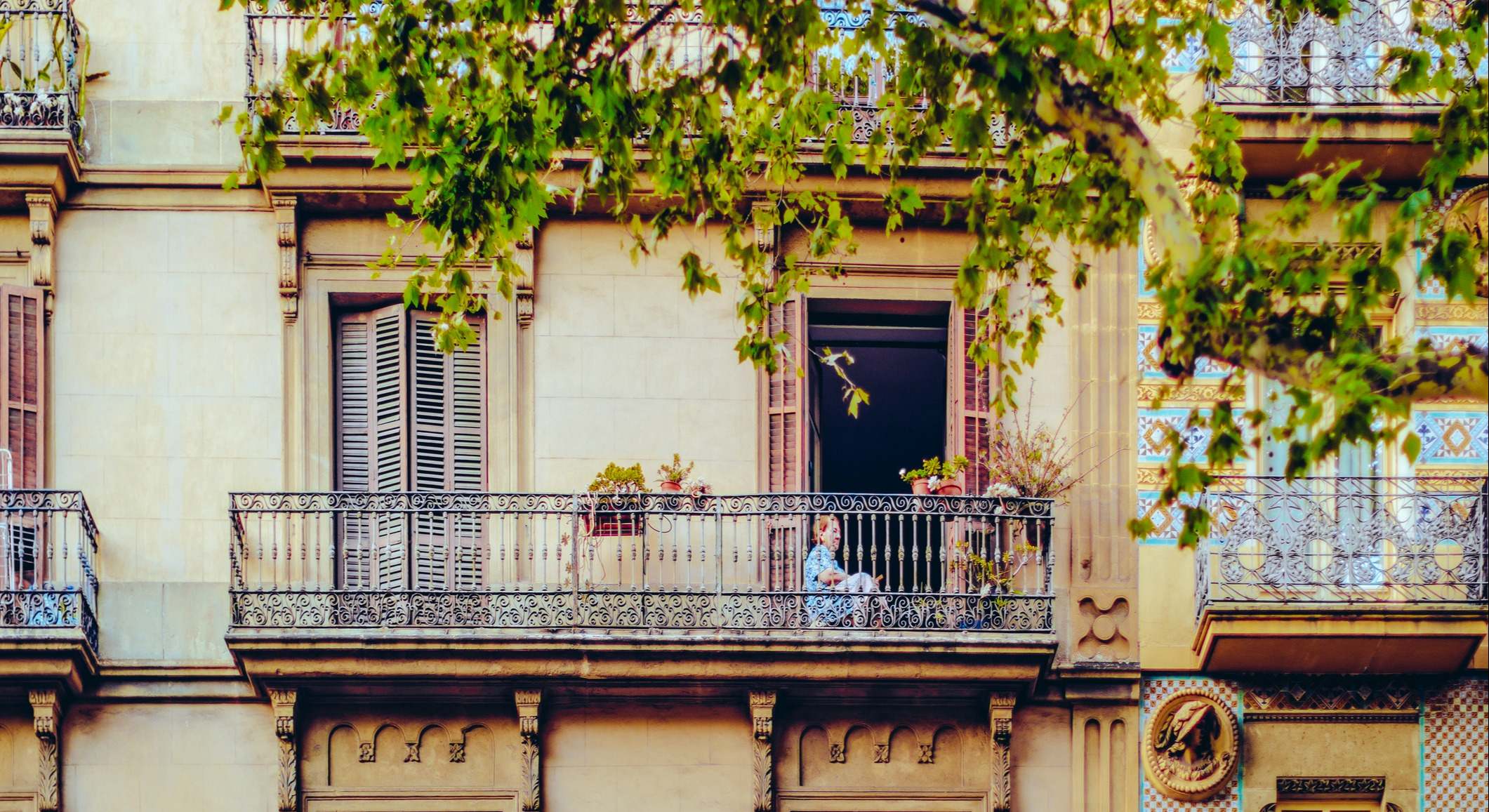 Señora en el balcón de un piso en La Rambla de Barcelona. Foto: iStock