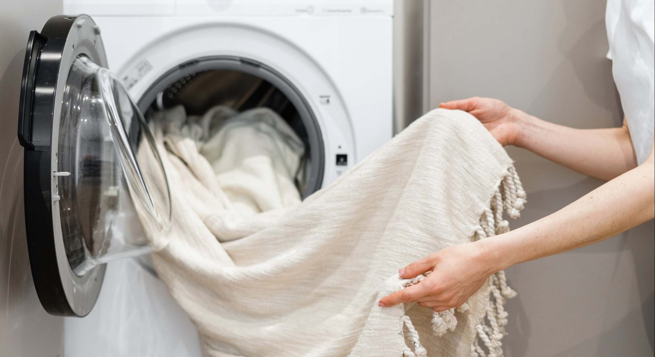Una mujer saca las prendas limpias de la lavadora. / Foto: iStock