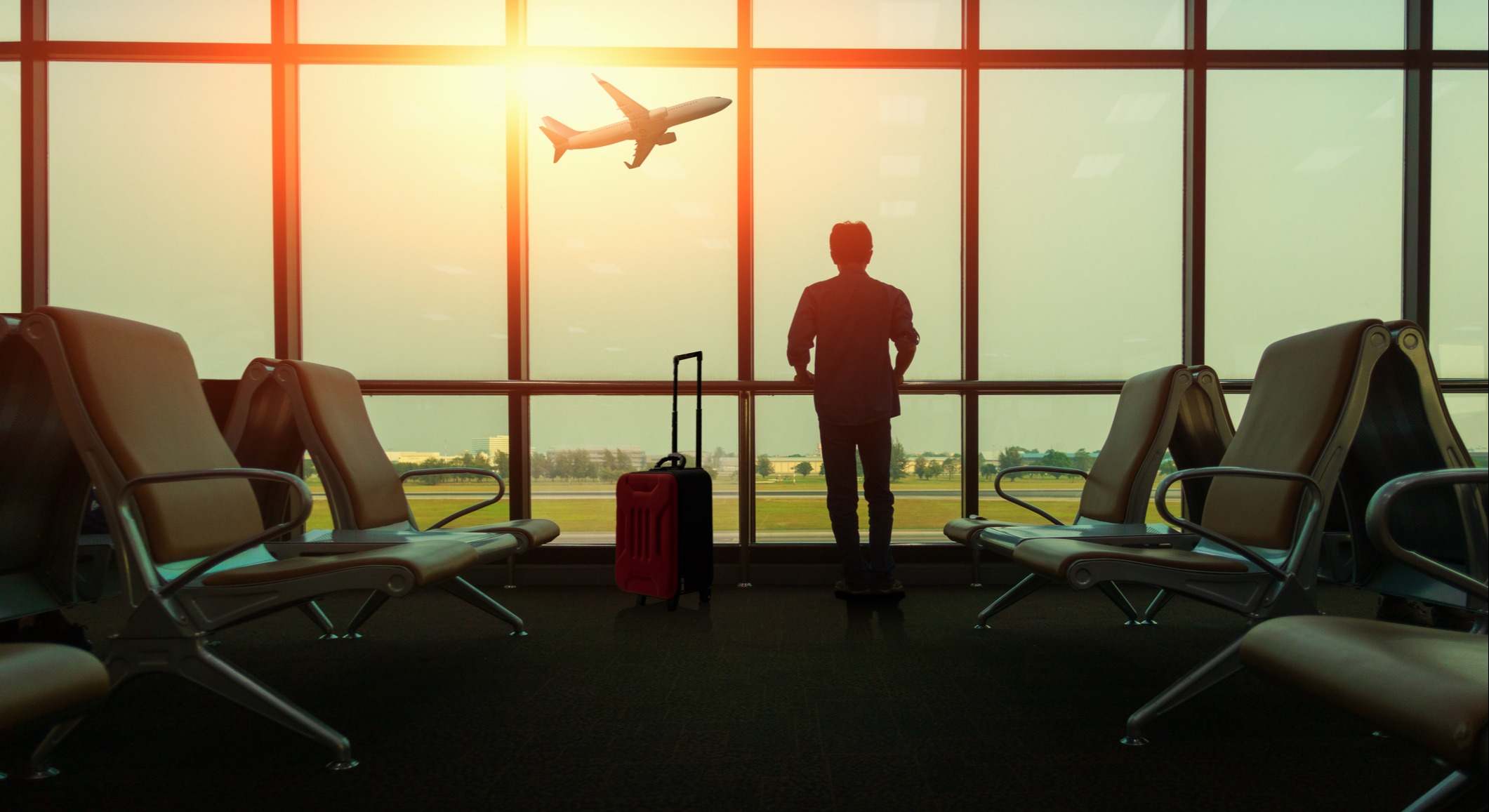 Asiento en la sala de embarque para ver avión, vista desde la terminal del aeropuerto