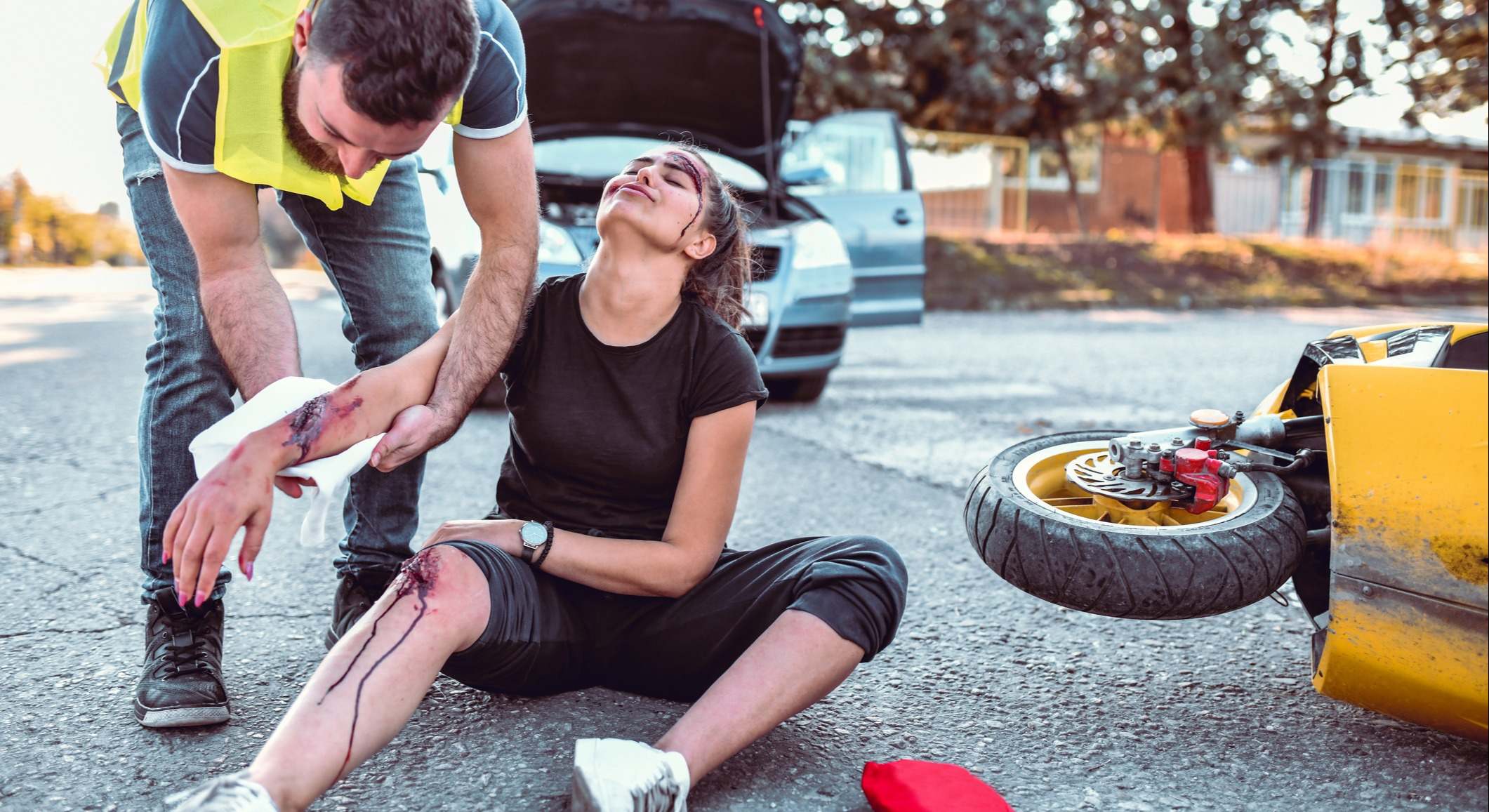 Hombre ayudando a una mujer lesionada con heridas tras un accidente