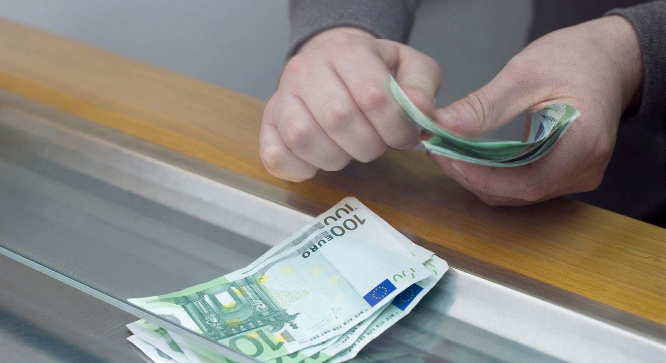 Un hombre paga en una caja de un banco. Foto: iStock