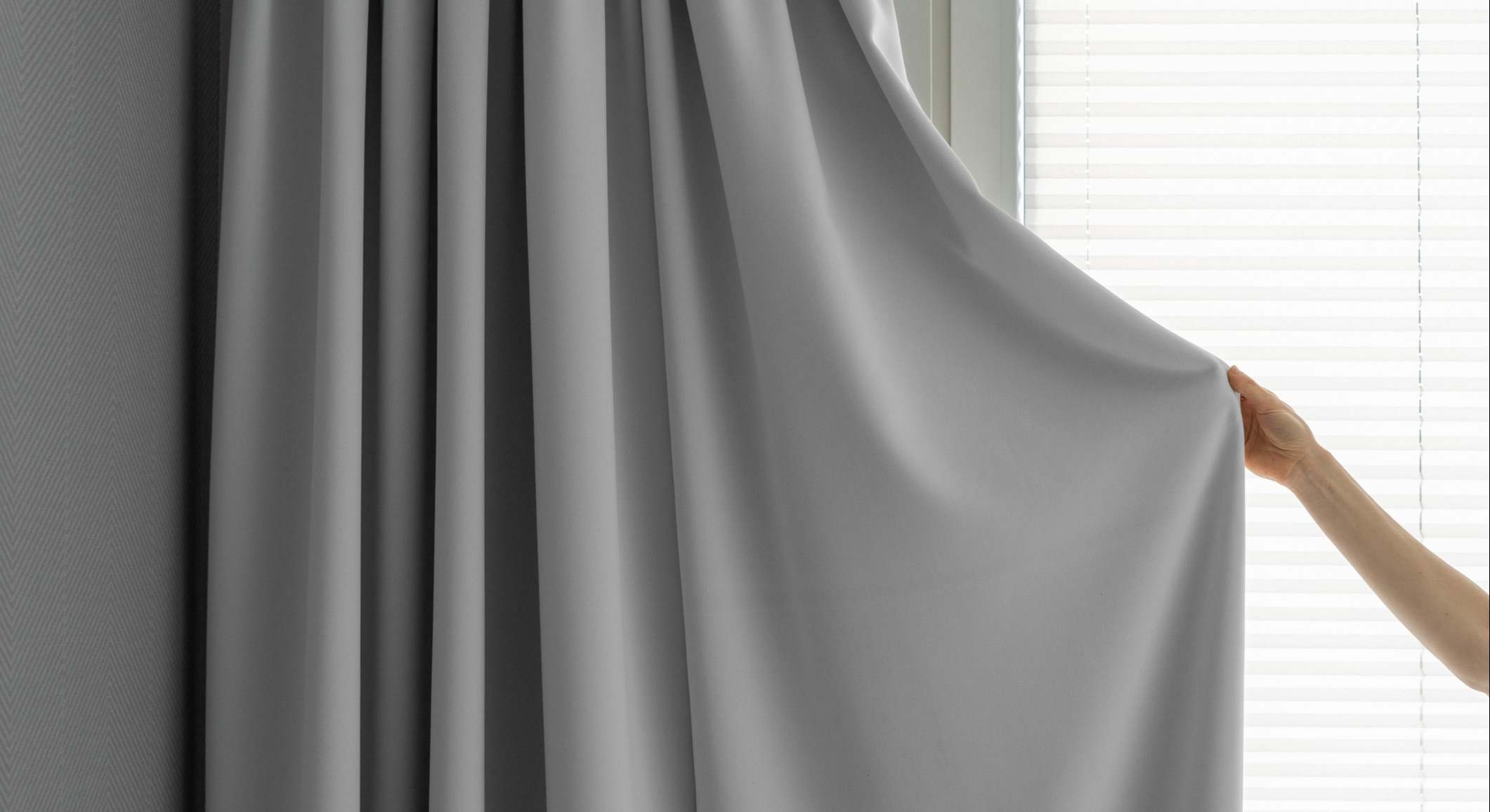 Una mujer cierra las cortinas de su hogar. / Foto: iStock