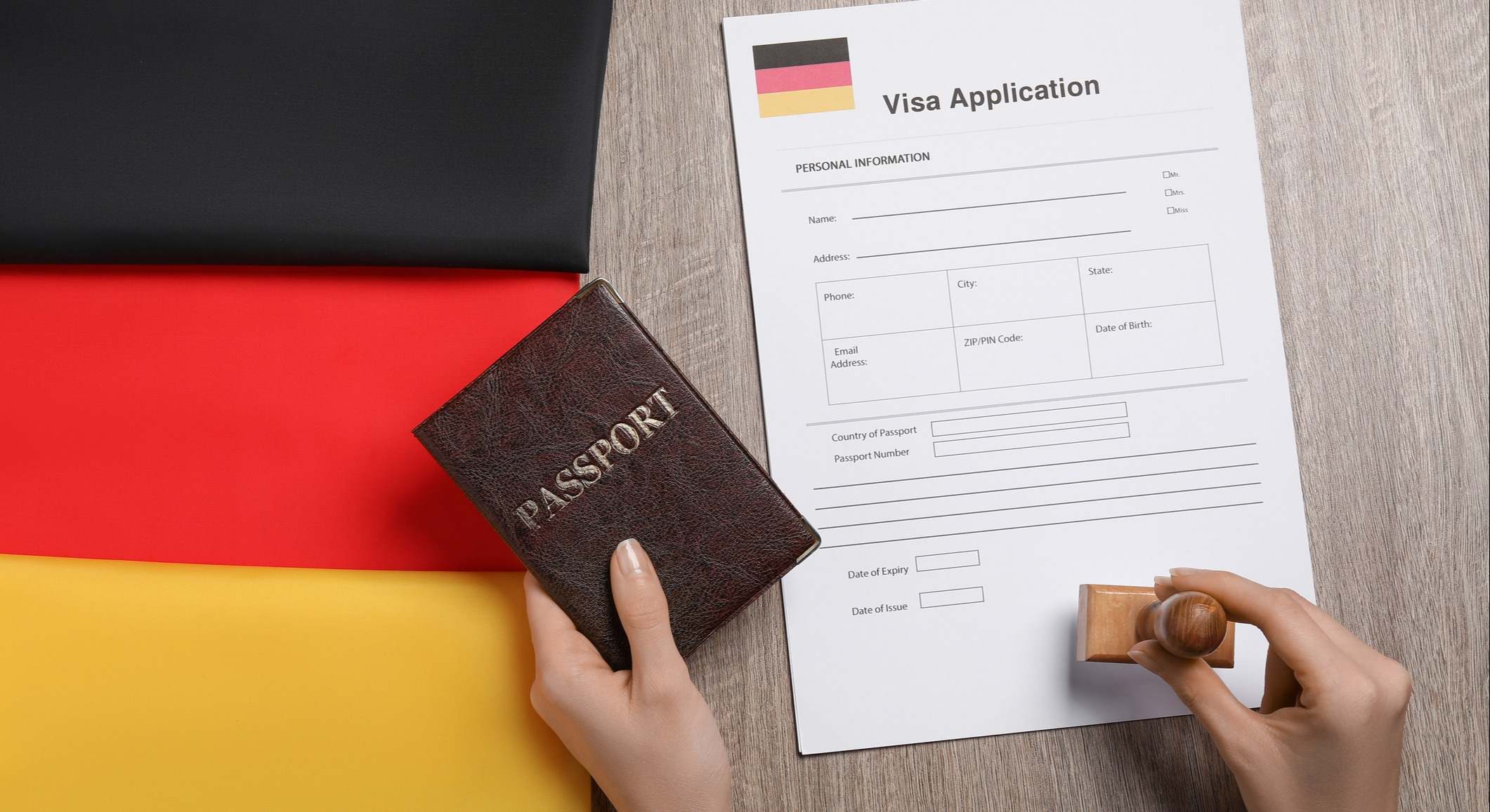 Mujer con el pasaporte en la mano sellando la solicitud de visa con la bandera de Alemania de fondo
