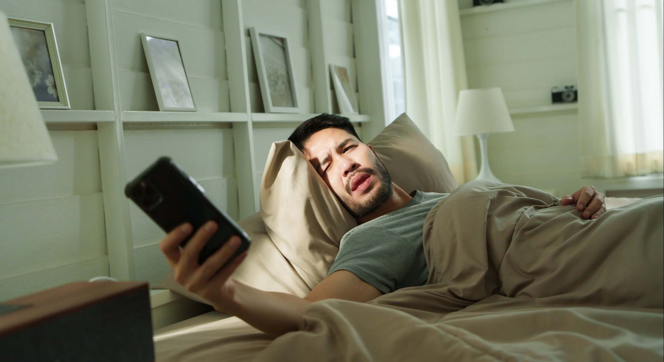 Chico mirando el móvil en la cama
