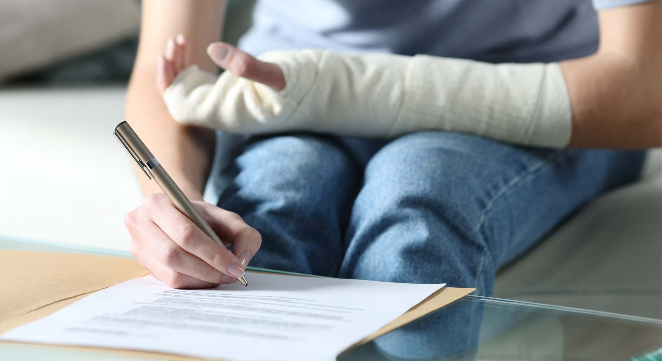 Mujer con brazo vendado firma un documento