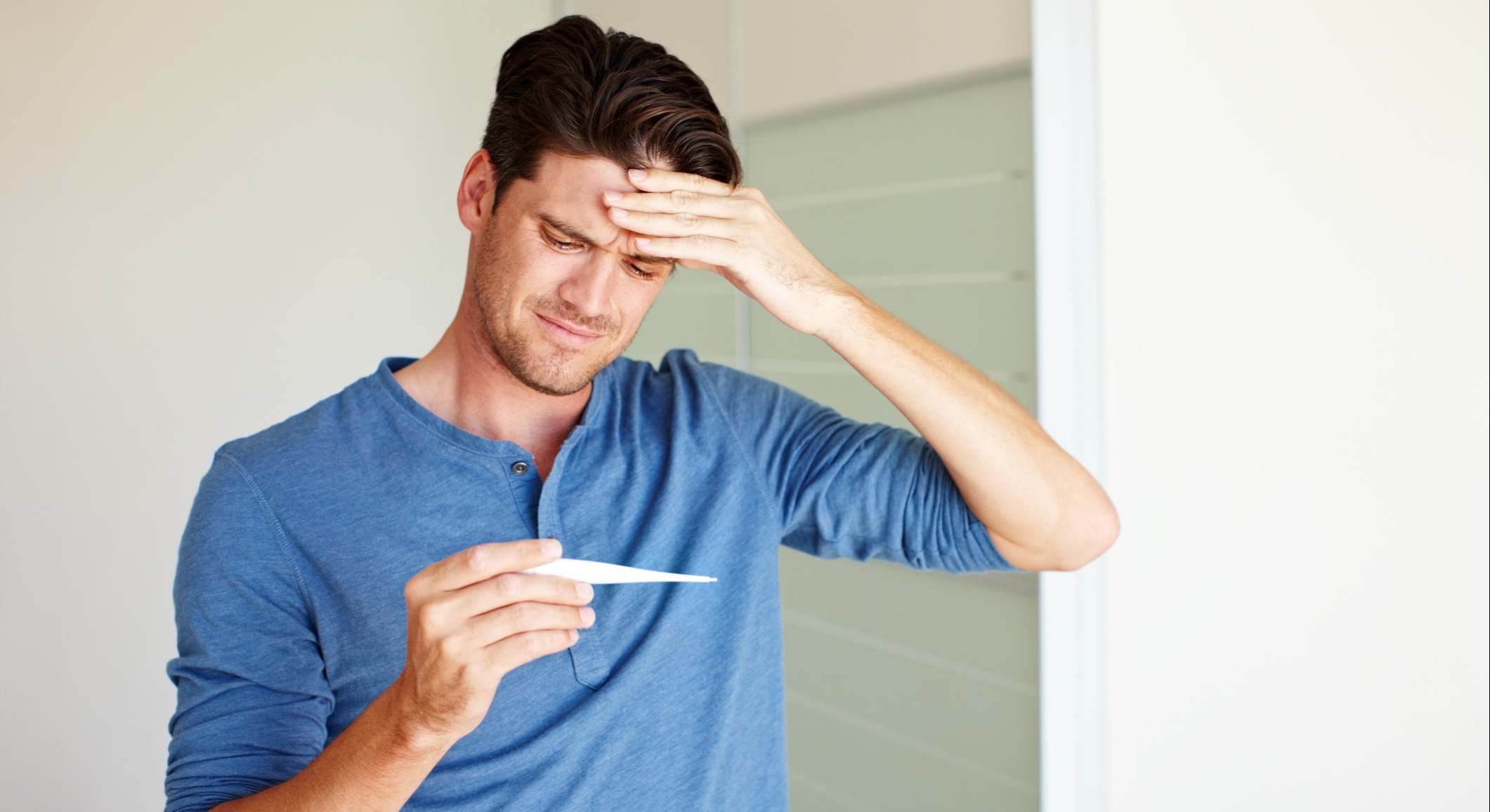 Hombre midiendo su temperatura corporal termómetro