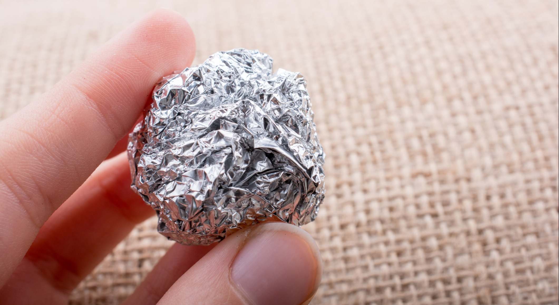 Papel de aluminio en forma de una esfera sobre fondo con textura