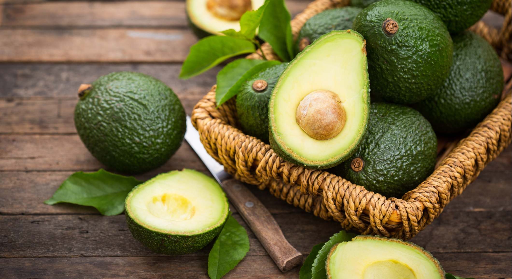 Aguacate en una cesta sobre una mesa de madera