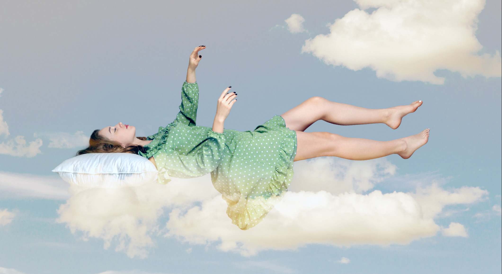 Mujer durmiendo sobre una almohada en el cielo